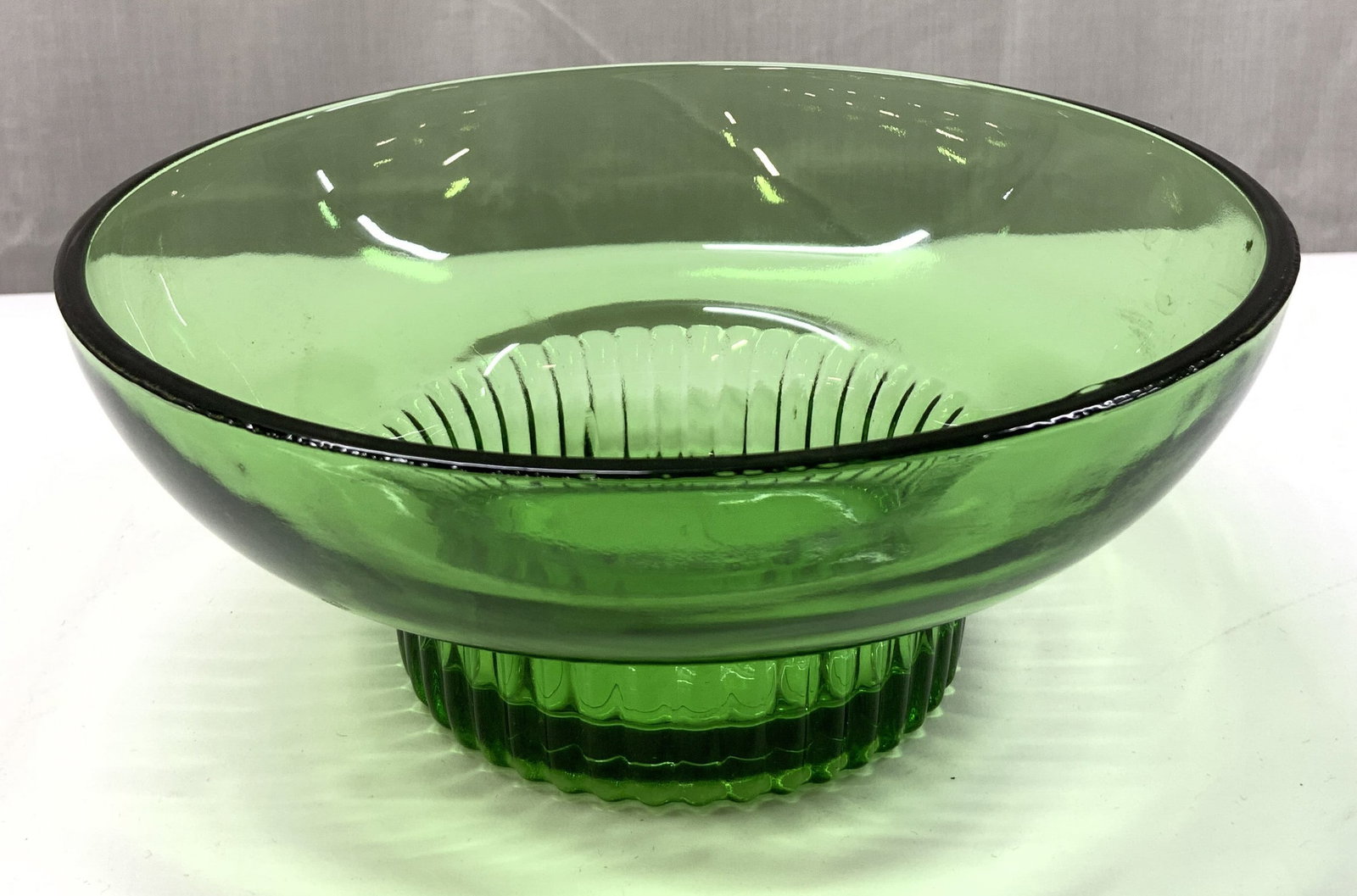 Footed Green Depression Glass Candy Bowl: Footed Green Depression Glass Candy Bowl Candy bowl has a pedestal/footed base. Base has a ribbed textured appearance. Has a vibrant green glass color. Surface wear consistent to age, use & exposure. 