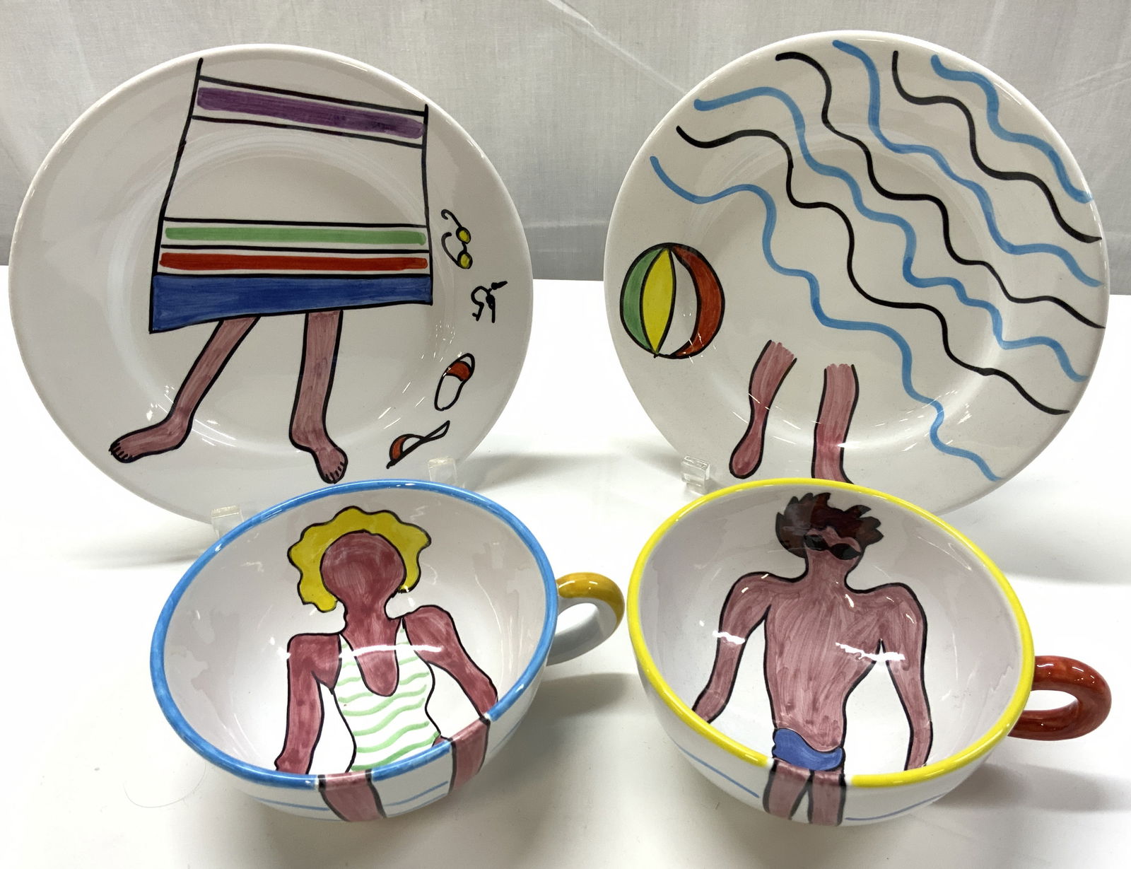 4 Paula Sweet Beach Ceramic Plates & Cups ITALY: 4 Paula Sweet Beach Ceramic Plates & Cups ITALY 2 plates & 2 cups. Each piece has a beach theme including, a beach ball, lady in a swimsuit, man in swimsuit, water, etc. Signed & marked on underside.