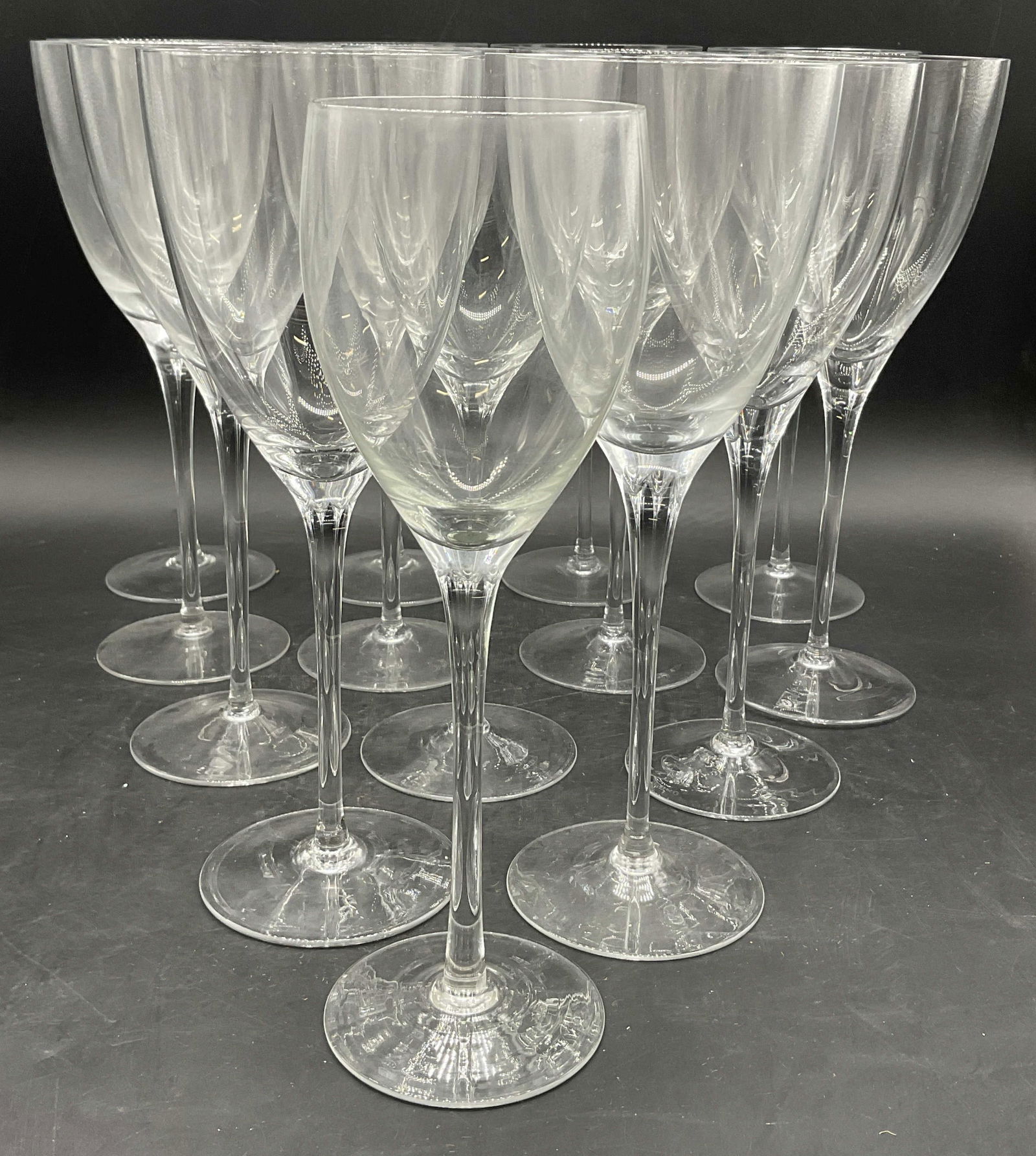 Lot 14 Crystal Stemware Wine Glasses: Lot 14 Crystal Stemware Wine Glasses. Thirteen are the same height, one is shorter. The talker glasses measure approx. 9.75H x 3.5W in. Surface wear consistent with age, use, and exposure. Chipping pr