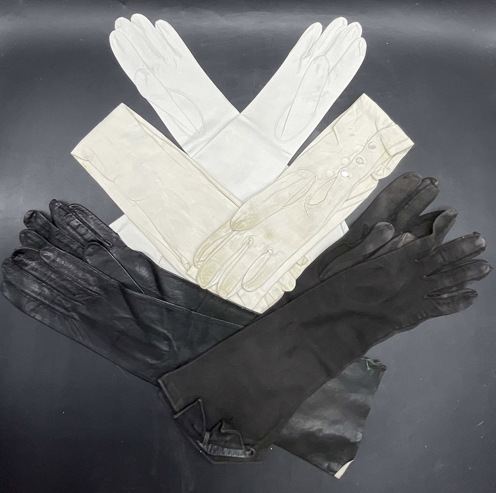 Lot 4 Opera Length Suede Gloves, KISLAV KID +: Four pairs of opera length gloves. Pieces are crafted from suede or suede style material. Black, white, and cream hues. KISLAV KID, made in France, gloves measures approx. 15L x 4.75W in. Discoloratio