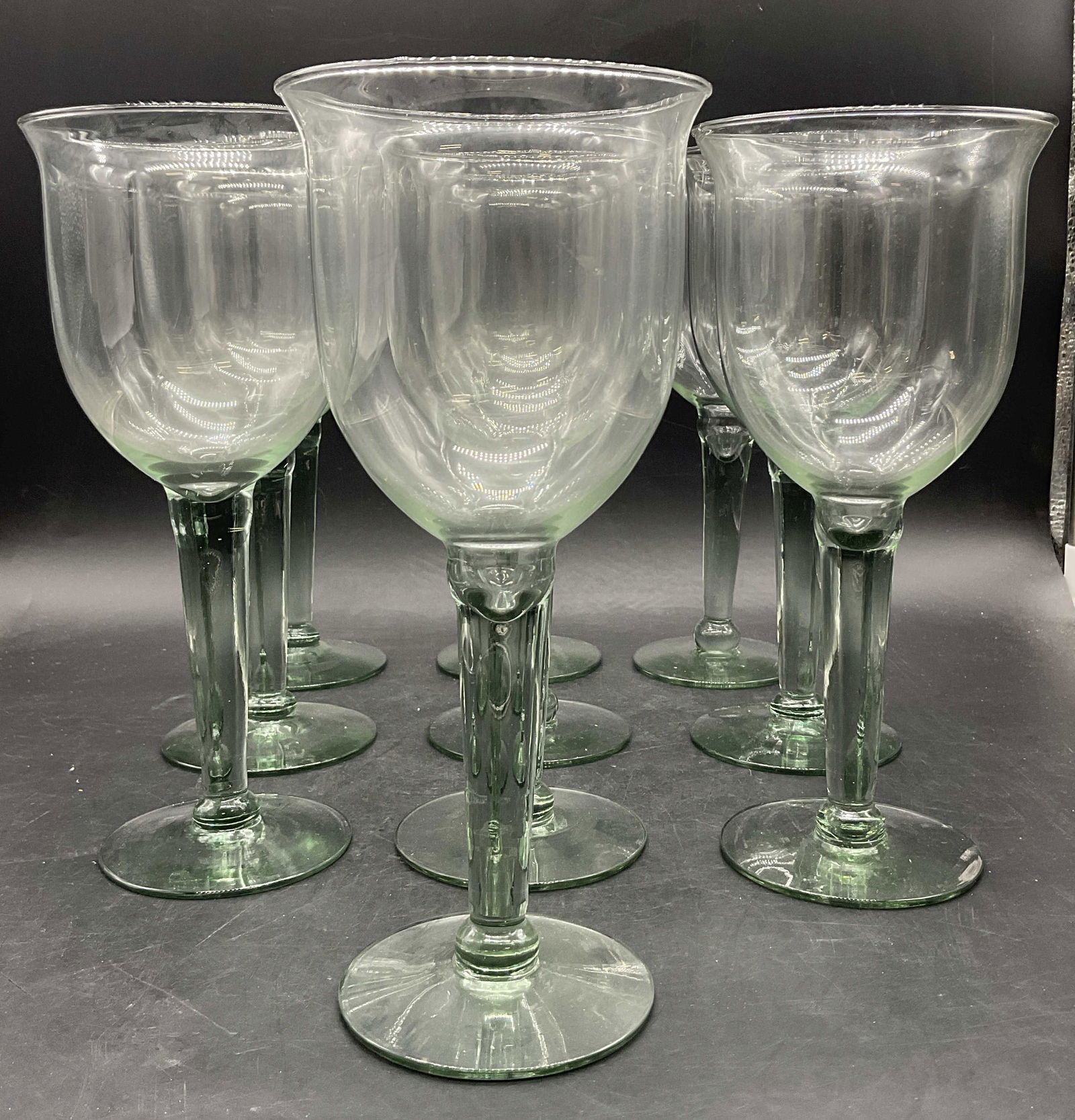 Set 10 Glass Stemware Wine Goblets: Set 10 Glass Stemware Wine Goblets. Light green hue to the pieces. Measures approx. 9.5H x 4.25W in. Some variations to the sizes of the pieces. Surface wear consistent with age, use, and exposure. So