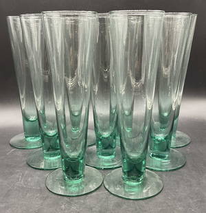 Set 9 Glass Stemware Champagne Flutes: Set of 9 Glass Stemware Champagne Flutes. Light green hue to the glasses. Measures approx. 9.5H x 3.25W in. Width measured at the base. Surface wear consistent with age, use, and exposure. Some imperf