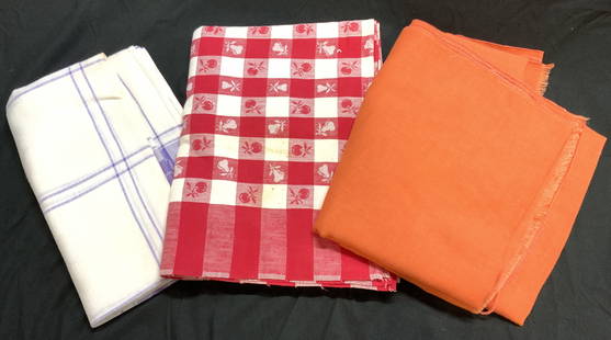 Lot 3 Vintage Assorted Table Cloths: Lot includes 3 table cloths. One orange, 1 checkered with cherry and pear pattern, & 1 white with purple toned detail. Each tablecloth is vintage. Largest measures approximately 81 inches long 54 inch