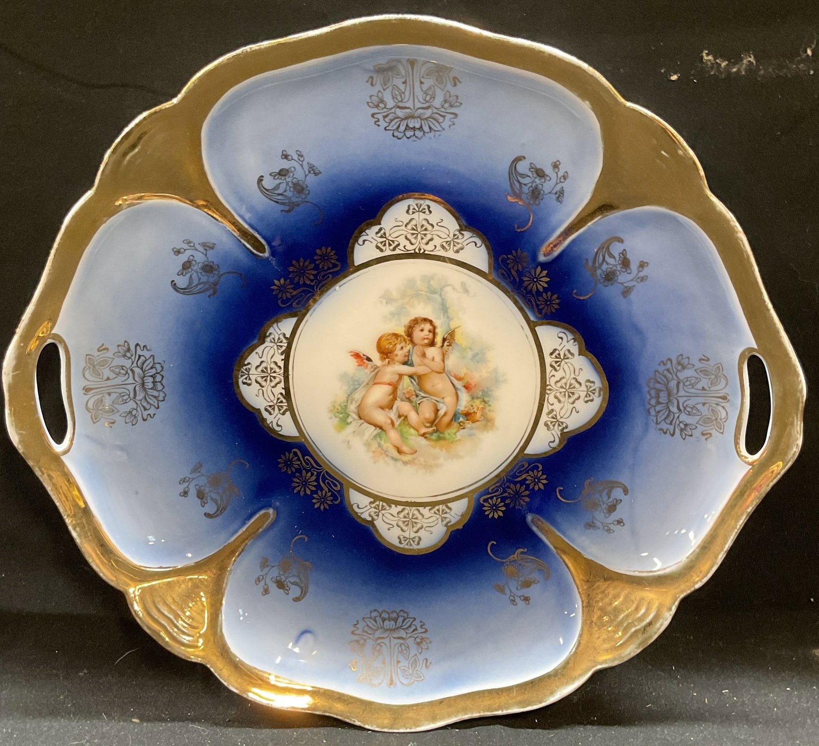 Vtg Gilt porcelain Hand Painted Cherub Platter: Vintage porcelain platter with handles. Hand painted blue with gilt decoration and cherub motif. Measures approx 10.5 inches wide. Some wear including scratching and loss to paint. Platter, porcelain 