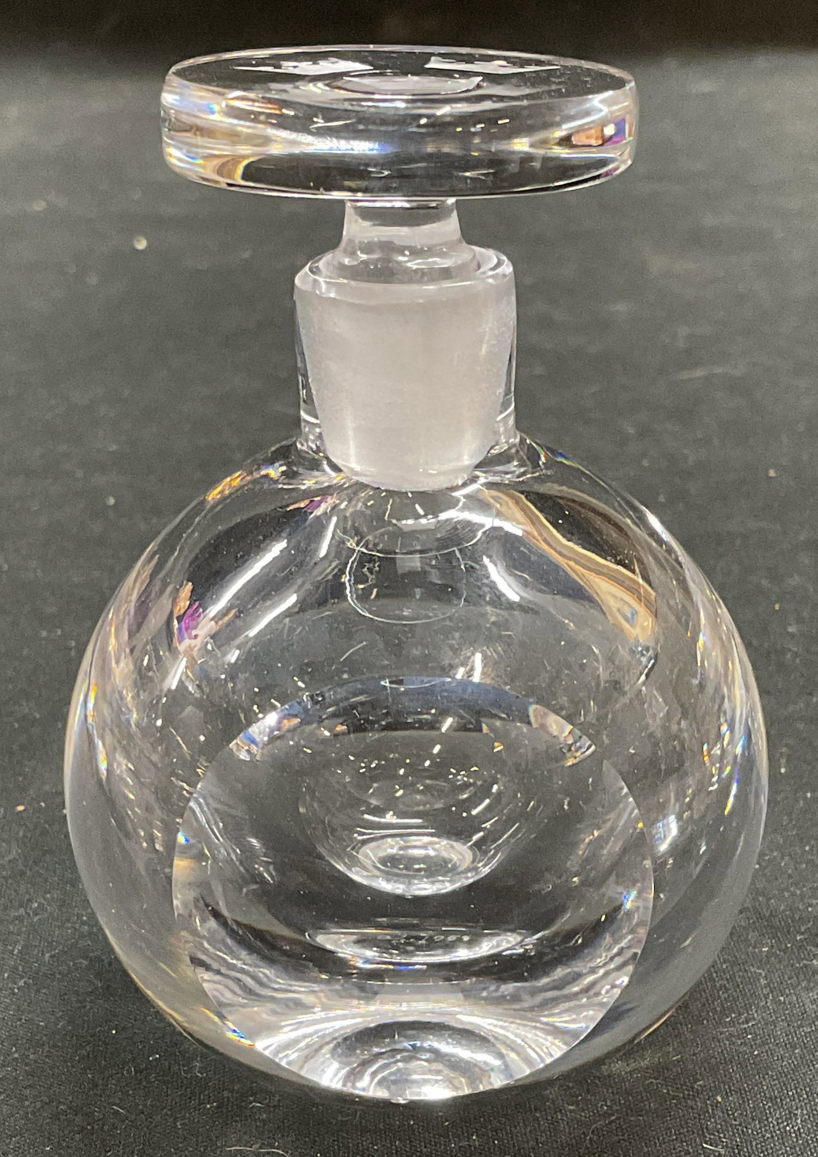 Signed Faceted Round Art Glass Perfume Bottle: Signed round art glass perfume bottle with faceted side detail and etched crown motif stopper. Signed illegibly. Measures approx 2.25 x 3.25 inches. Some scratching observed. Art glass, art glass perf