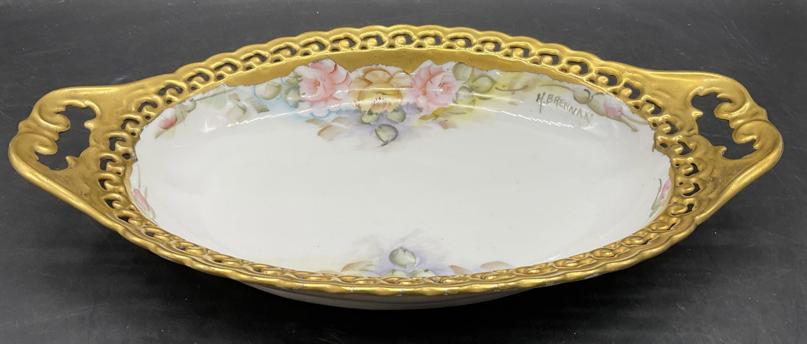 H. BRENNAN Sig Hand Painted Floral Porcelain Dish: H. BRENNAN Signed Hand Painted Floral Porcelain Dish. Gilt line work to the pierced porcelain edge. Signed H. BRENNAN to the obverse. Measures approx. 11.25W x 1.75H in. Losses to paint and surface we