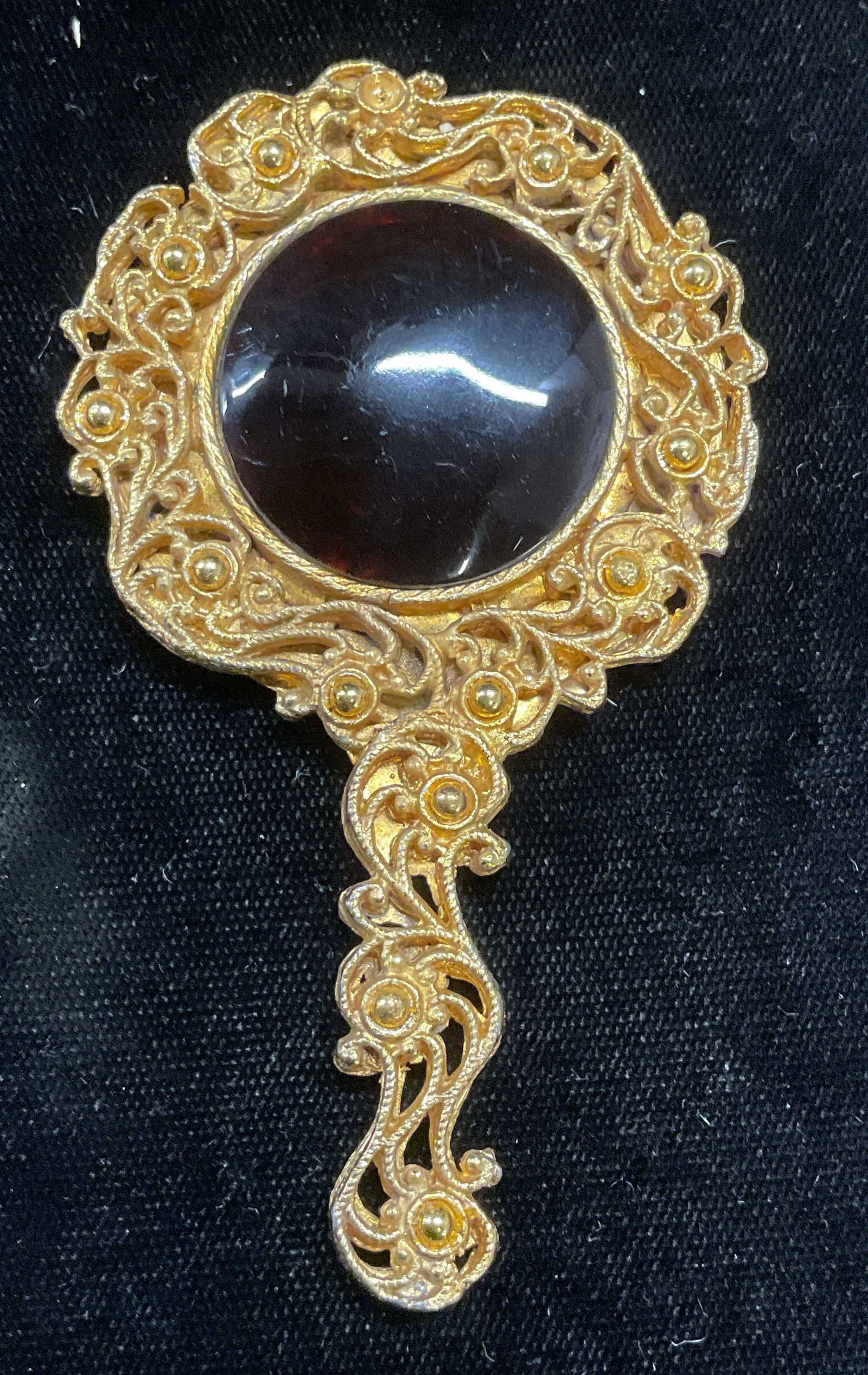 Vintage Gold Tone Filigree Hand Mirror: Vintage gold tone filigree hand mirror with black faux cabochon. Measures approx 3.5 x 2 inches. Some wear consistent with exposure. Inventory from Manhattan Jewelry store circa 1950s-1960s. Mirror, v