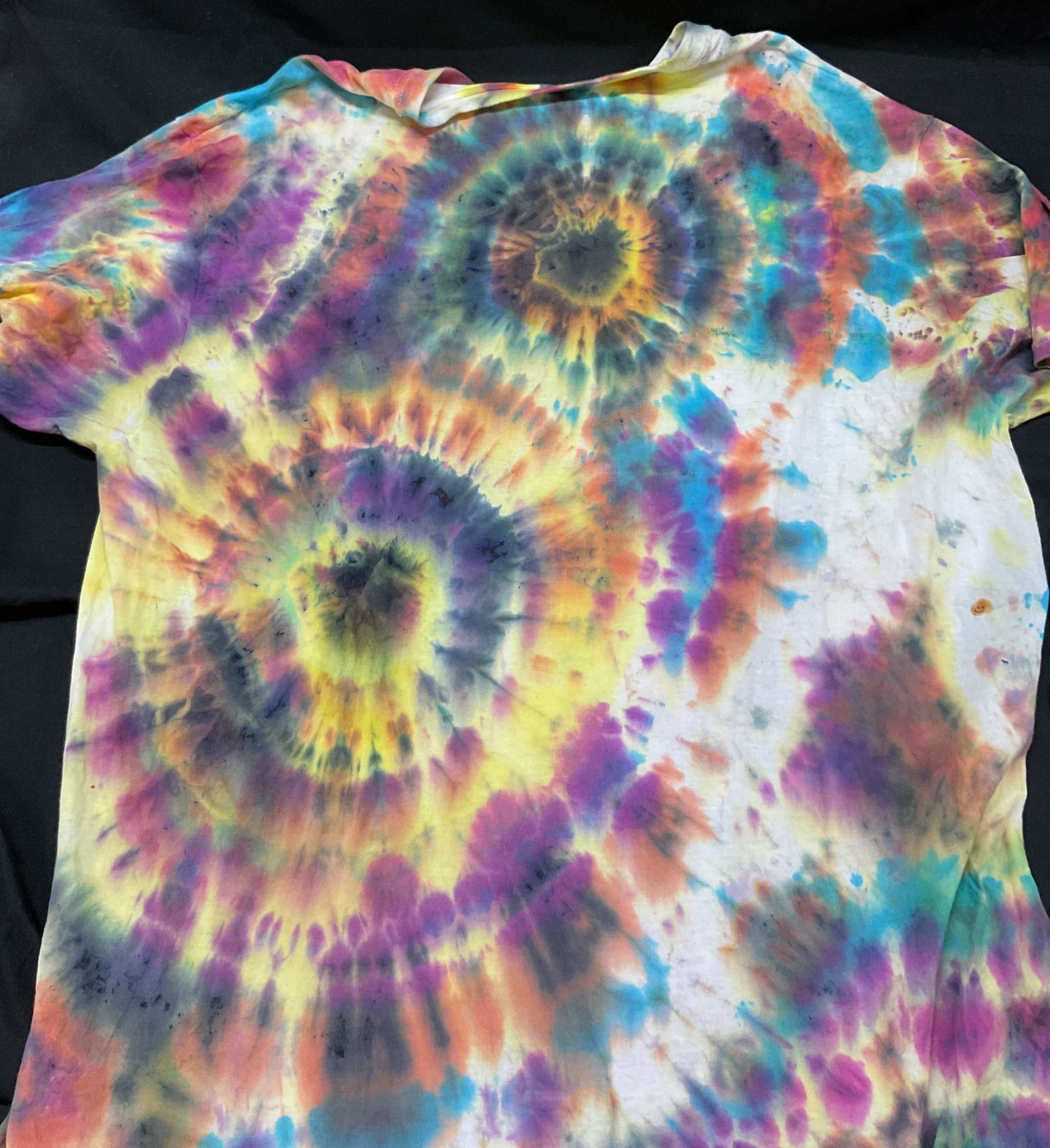 Hanes Rainbow Tie Dye Cotton T-shirt: Hanes Rainbow Tie Dye Cotton T-shirt. Multicolored splatter ringed pattern. 100% cotton. Size 2XL. Some wear consistent with exposure, light discoloration, staining, and tearing. Hanes T-shirt, tie dy
