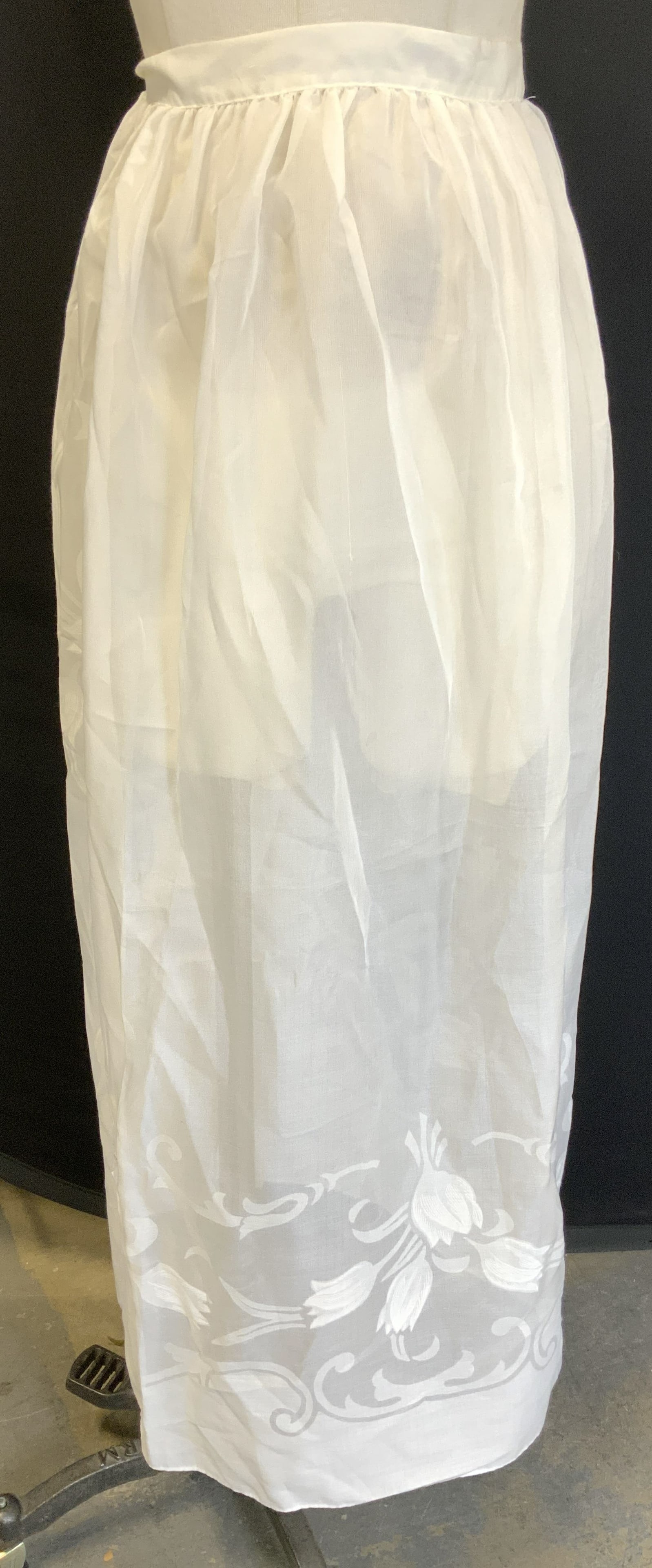 MAKYLENE White Intricate Floral Apron SPAIN: MAKYLENE White Intricate Floral Apron SPAIN White apron with an intricate floral pattern on the bottom ends & sides. Material is 67% polyester & 33% mix cotton. Signed & marked. Reads MAYKLENE. Surfac