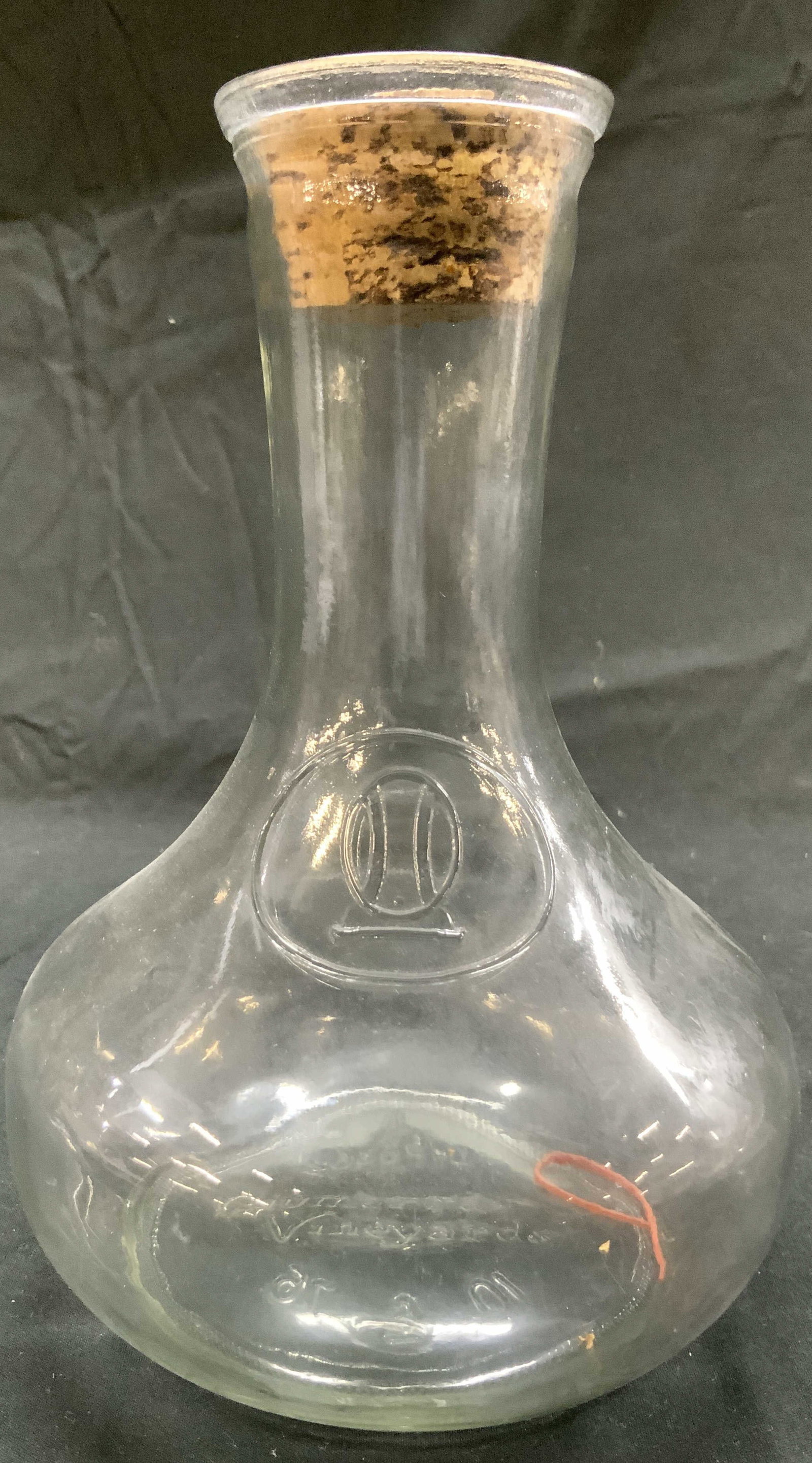 EIVMARRA VINEYARDS Art Gls Decanter W Cork Stopper: Underside reads EIVMARRA VINEYARDS. Decanter is vintage. Piece is glass with tan toned cork stopper. Decanter has wide base. Piece measures approximately 8 inches tall 6 inches wide. Decanter, vessel,