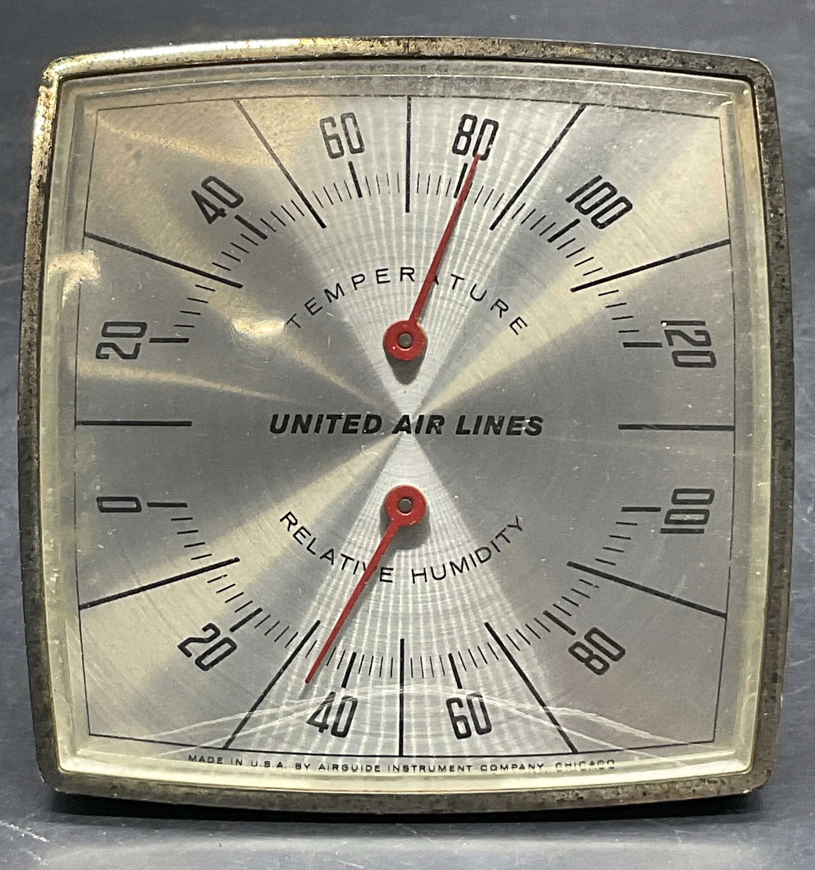UNITED AIR LINES Vintage Temp / Humidity Gauge: UNITED AIR LINES Vintage Temperature / Humidity Gauge. Kickstand to the reverse. Measures approx. 3.5L x 3.5W in. Crafted from metal and plastic materials. Not tested for function. Surface wear consis