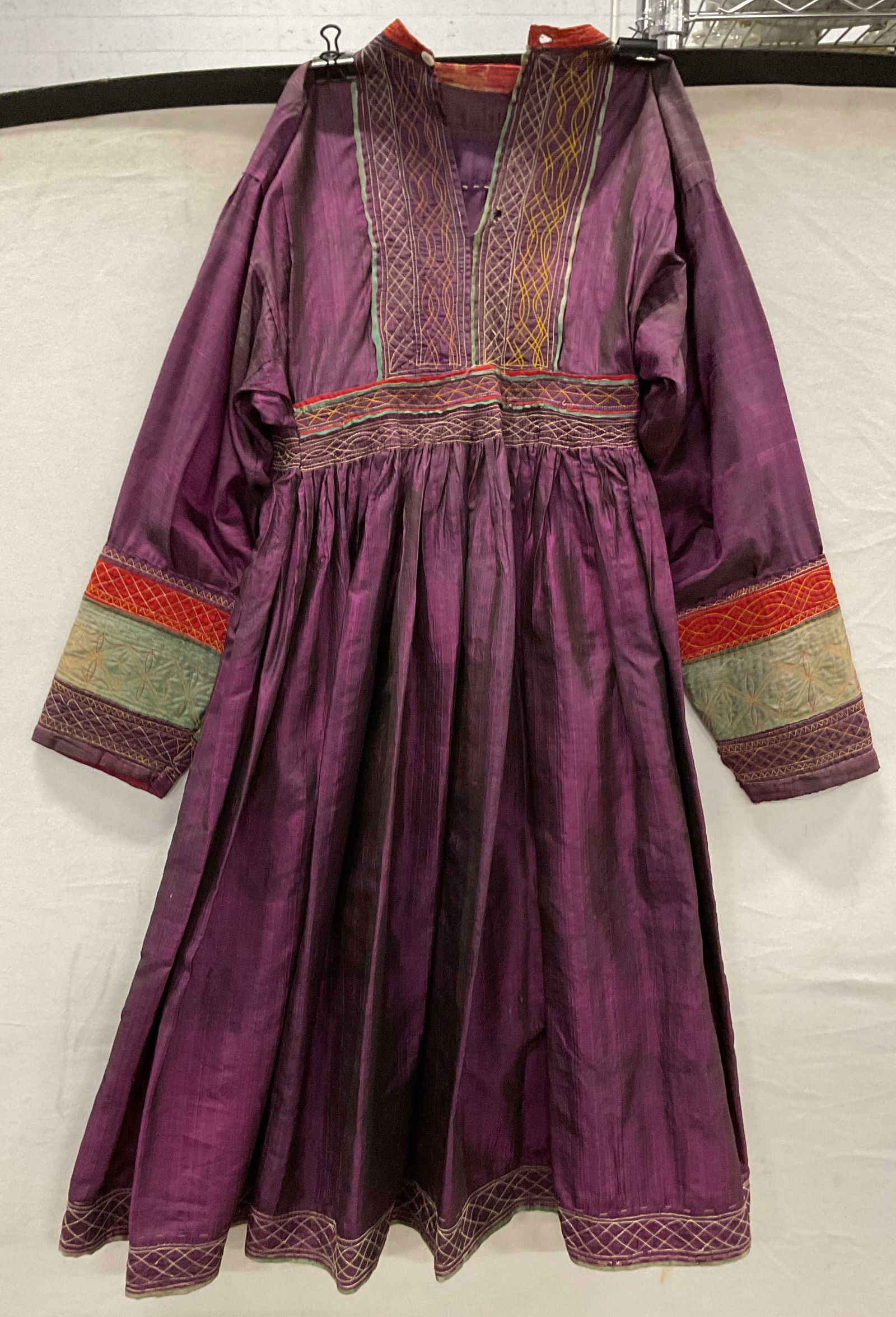 Vtg Purple Afghan Hand Embroidered Silk Dress: Vintage purple Afghan silk dress. Hand embroidered. Red and green yellow accent colors. Cinched waist. Front buttons. No material tags present, possibly silk. 14 inches across waist. Some tearing, hol