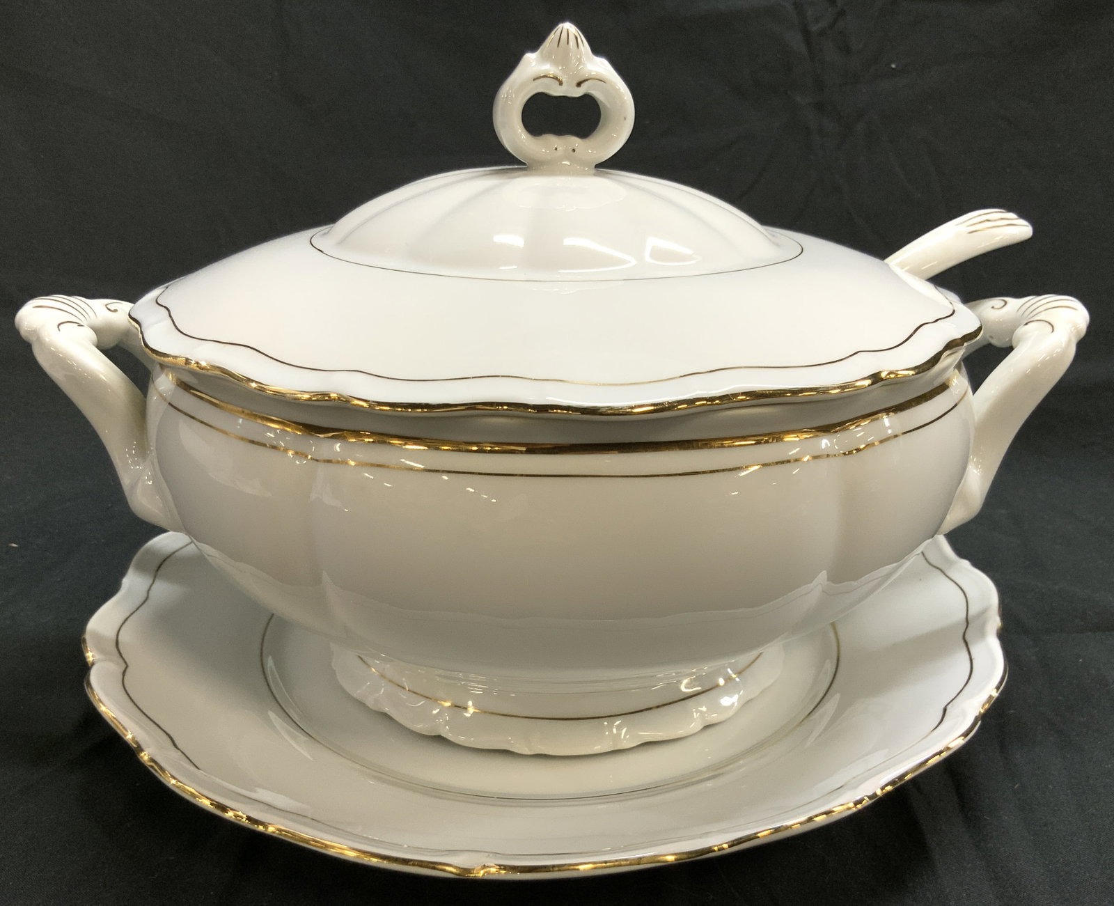 FINE BOHEMIAN CHINA Tureen W Lid Ladle & Plate: Underside is marked FINE BOHEMIAN CHINA EMPRESS MADE IN CZECHOSLOVAKIA. Lot includes tureen, lid, ladle and plate. Each piece is white with gilt rims. Tureen has handles. Tureen measures approximately