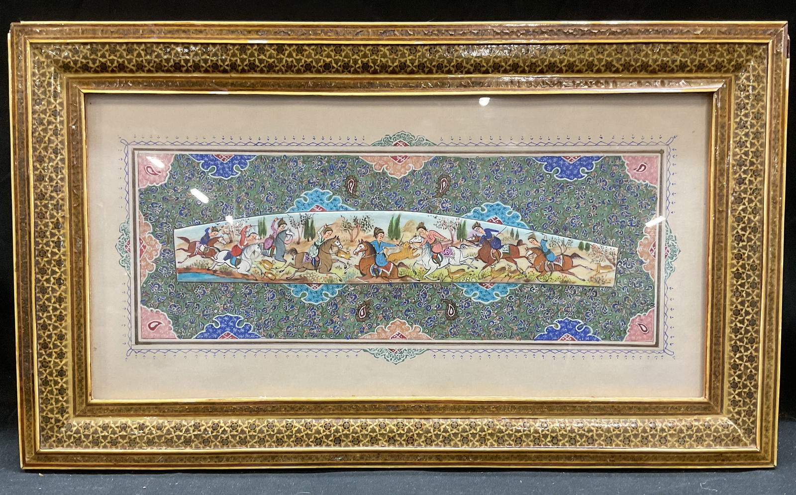 Framed Persian Miniature Hunt Scene Painting: Framed Persian miniature painting. Khatam marquetry frame. Painting appears to be on bone with hand painted decorative floral backing. Hunting scene with group of figures on horseback and animals. Not