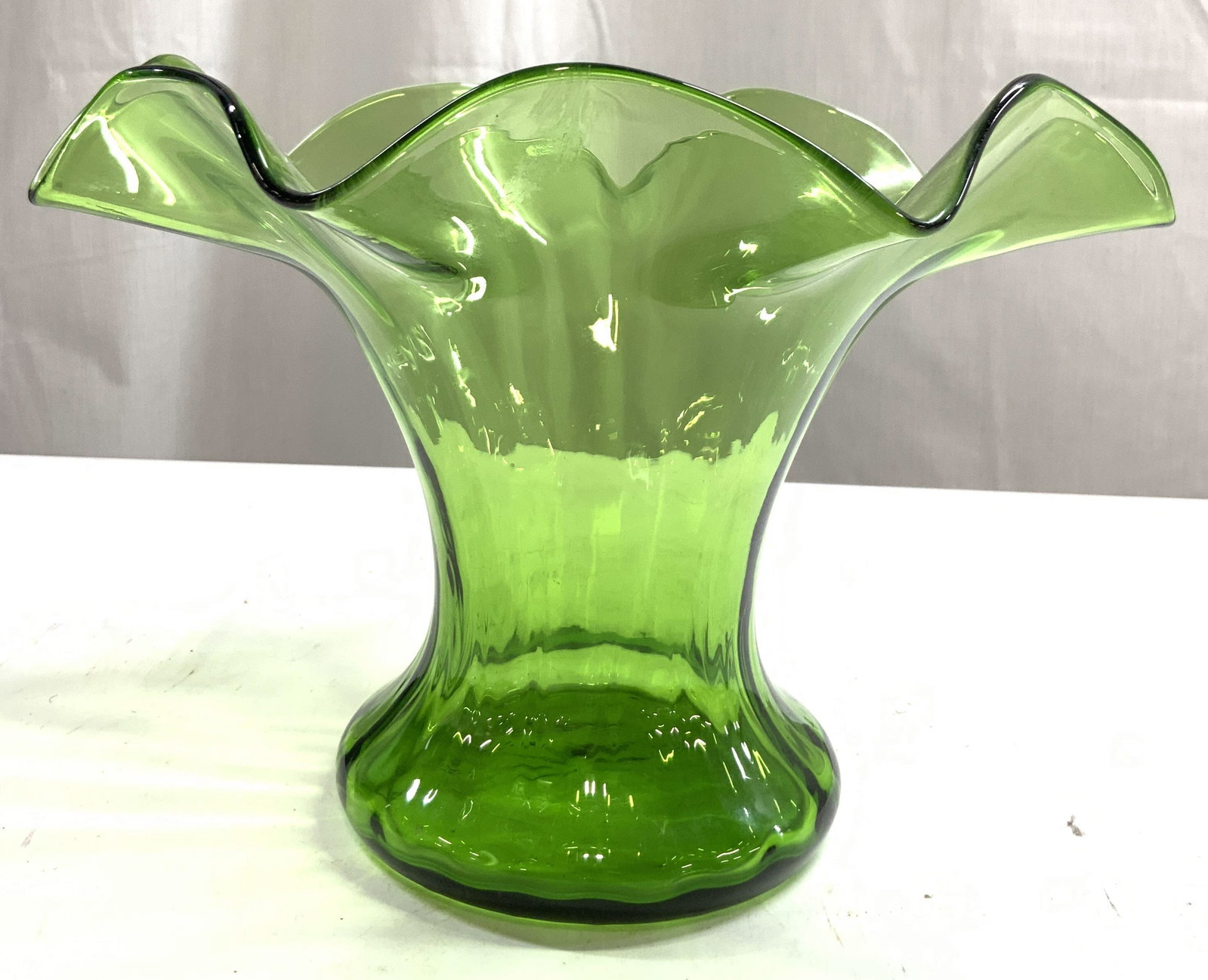 Vintage Art Glass Handkerchief Style Vase Green: Vase is green toned and glass. Piece has handkerchief style rim. Piece appears to be vintage, possibly hand blown. Vessel measures approximately 9.5 inches wide 7 inches tall. Vase, green vase, vessel