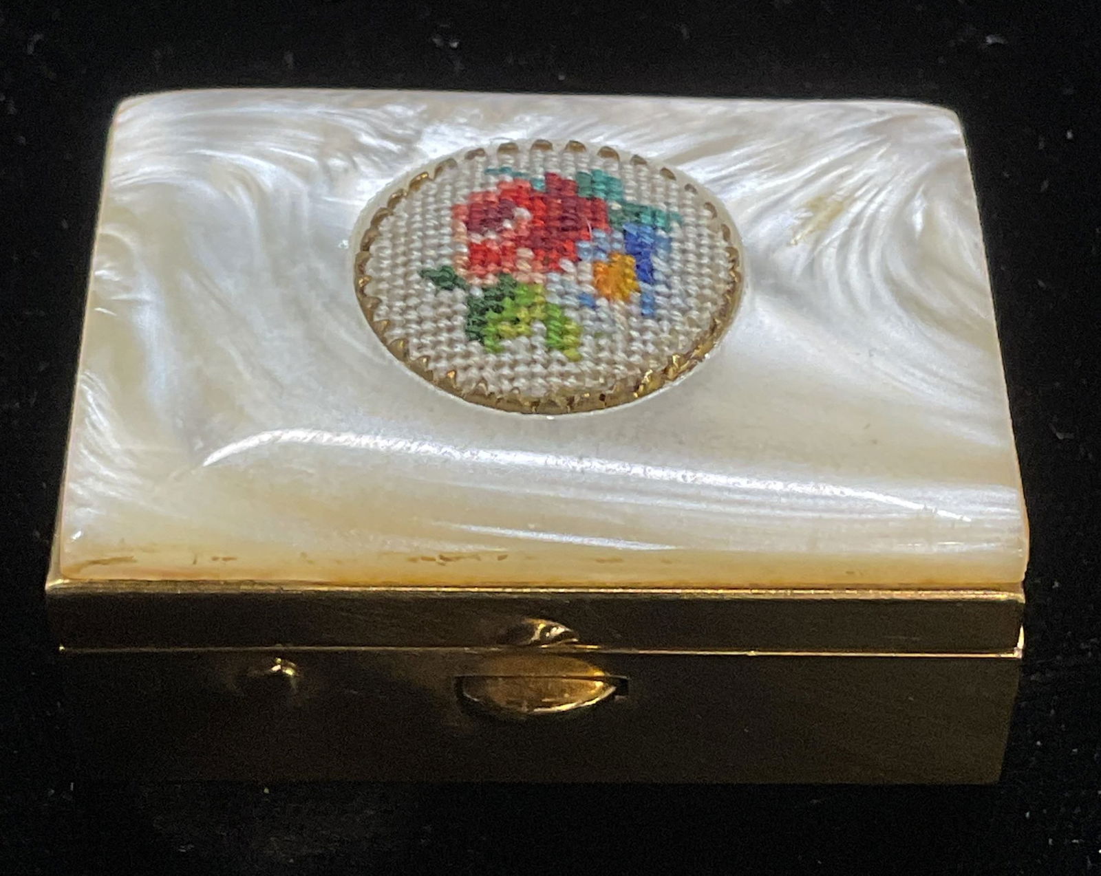 Vtg Schildkraut Faux MOP Needlepoint Pill Box: Vintage Schildkraut gold tone pill box with faux mother of pearl decoration and needlepoint floral motif. Measures approx 1.5 x 1 x .5 inches. Some wear consistent with exposure. Inventory from Manhat