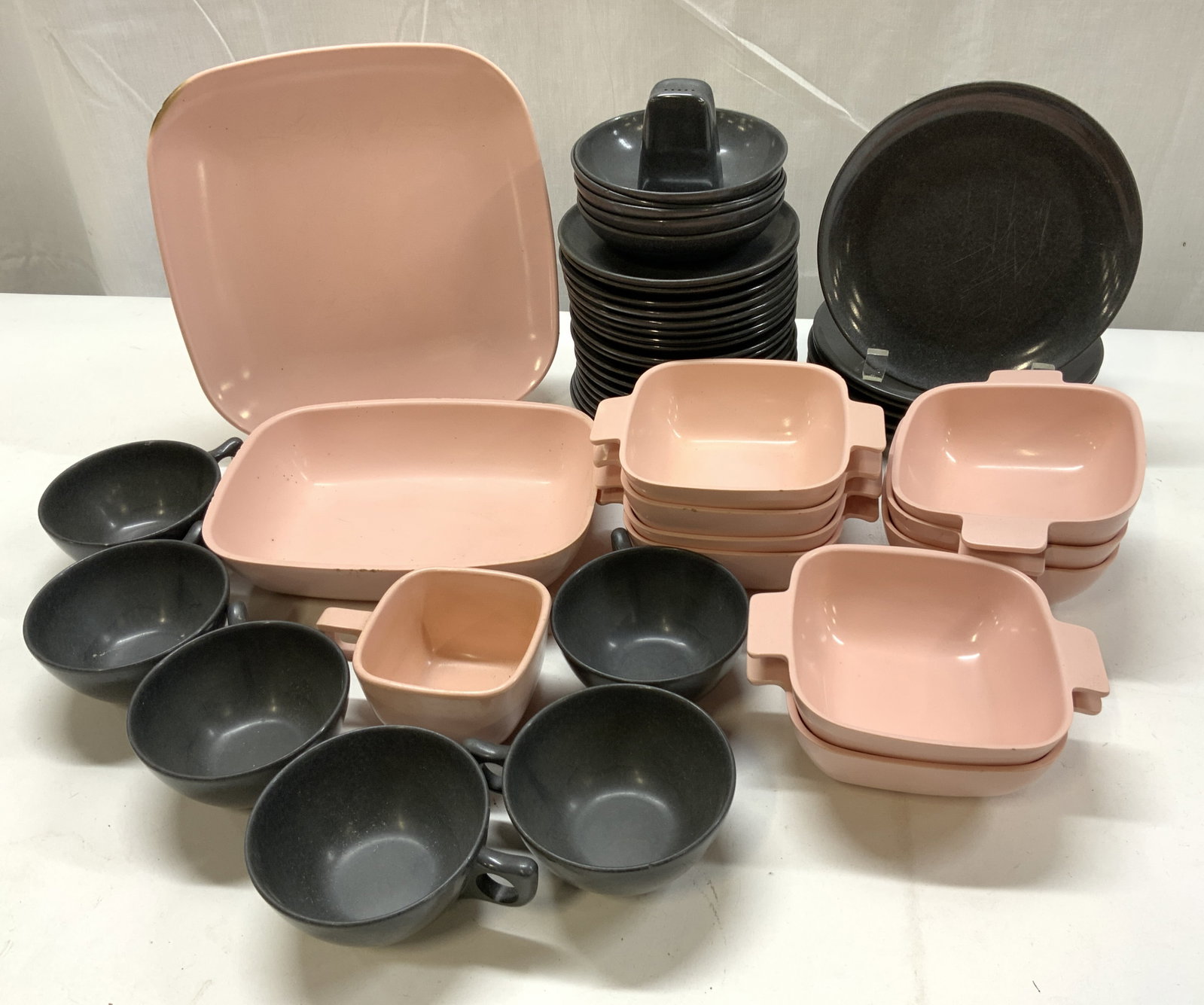 Lot 48+ Melmac Pink & Black Tableware BRANCELL: Lot 48+ Melmac Pink & Black Tableware BRANCELL 1 rectangular dinner plate, 1 rectangular bowl, 9 small bowls, 6 salad plates, 18 saucer plates, 1 salt shaker, 7 cups & 5 tiny bowls. Pieces have a salm