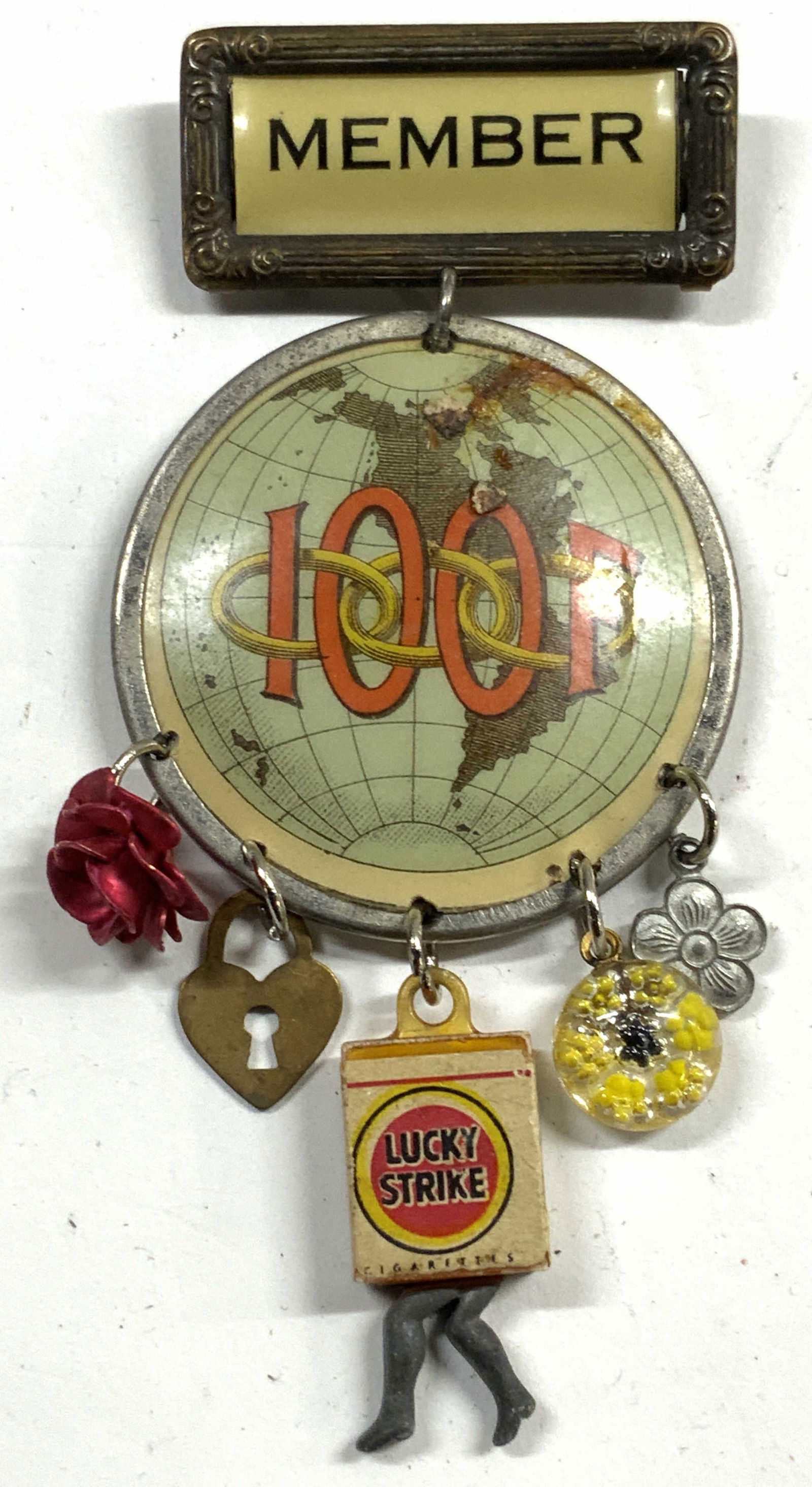 Vntg Pendant & Pin W Numerous Assorted Charms: Pin reads member. Attached to pedant which reads 100F. Attached to pendant is a flower, heart form lock, walking lucky strike box, and 2 floral charms. Together measures approximately 4 inches tall 2