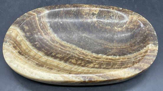 Polished Brown Banded Natural Stone Trinket Dish: Polished Brown Banded Natural Stone Trinket Dish. Oval form. Measures approx. 7.75W x 1H in. Measured at widest point. Surface wear, residue, and chipping present. Stonework, natural stone, home decor