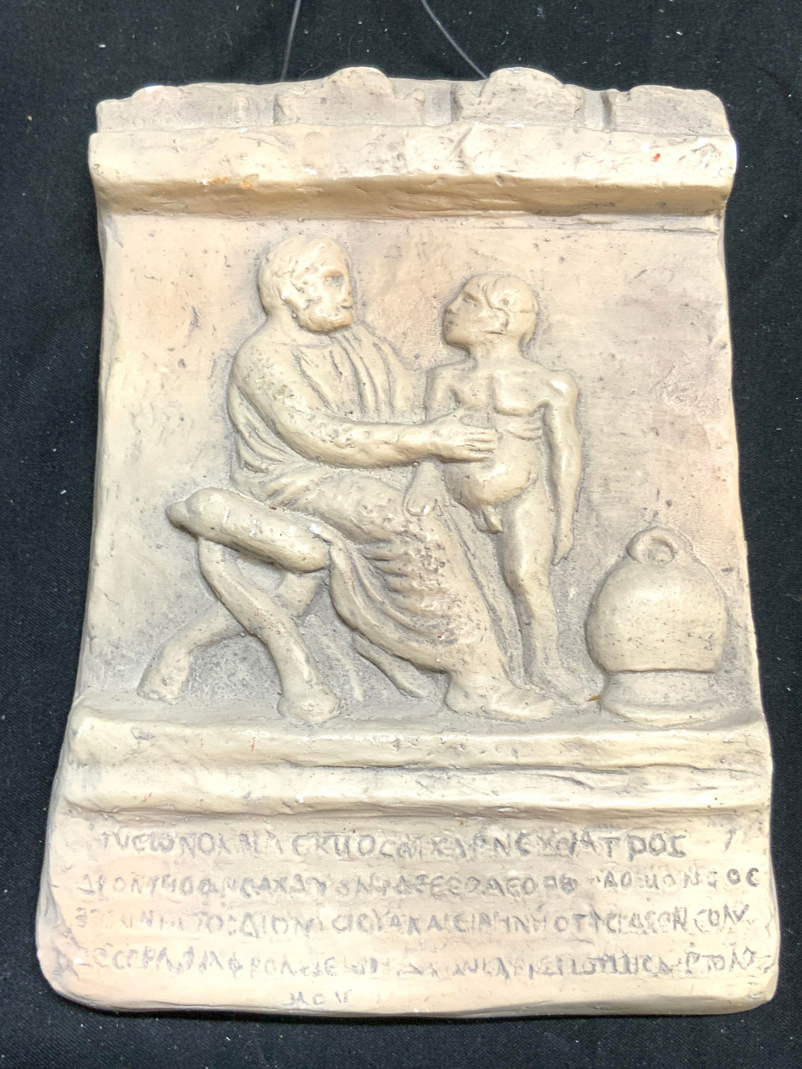 Tombstone of Jason The Physician Wall Hanging: Backside has info which reads Tombstone of Jason The Physician. Wall hanging is cream toned and plaster. Depicts one seated male figure and 1 nude male figure. Measures approx 6.25 in by 4.5 in, appro