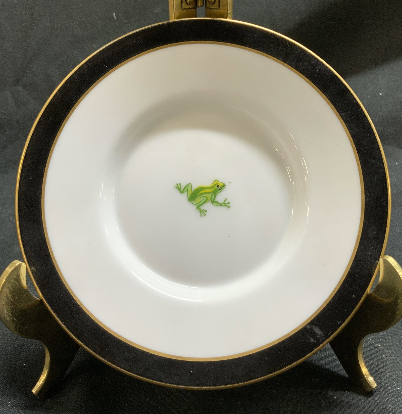 1988 LynnChase Jaguar Jungle Demitasse Dish JAPAN: Dish consists of a black border and 24 karat gold rim. Center of dish has a precious green frog. Signed & marked. Underside reads CHASE, JAGUAR JUNGLE. DECORATED WITH 24 KARAT GOLD. MADE IN JAPAN. Sur