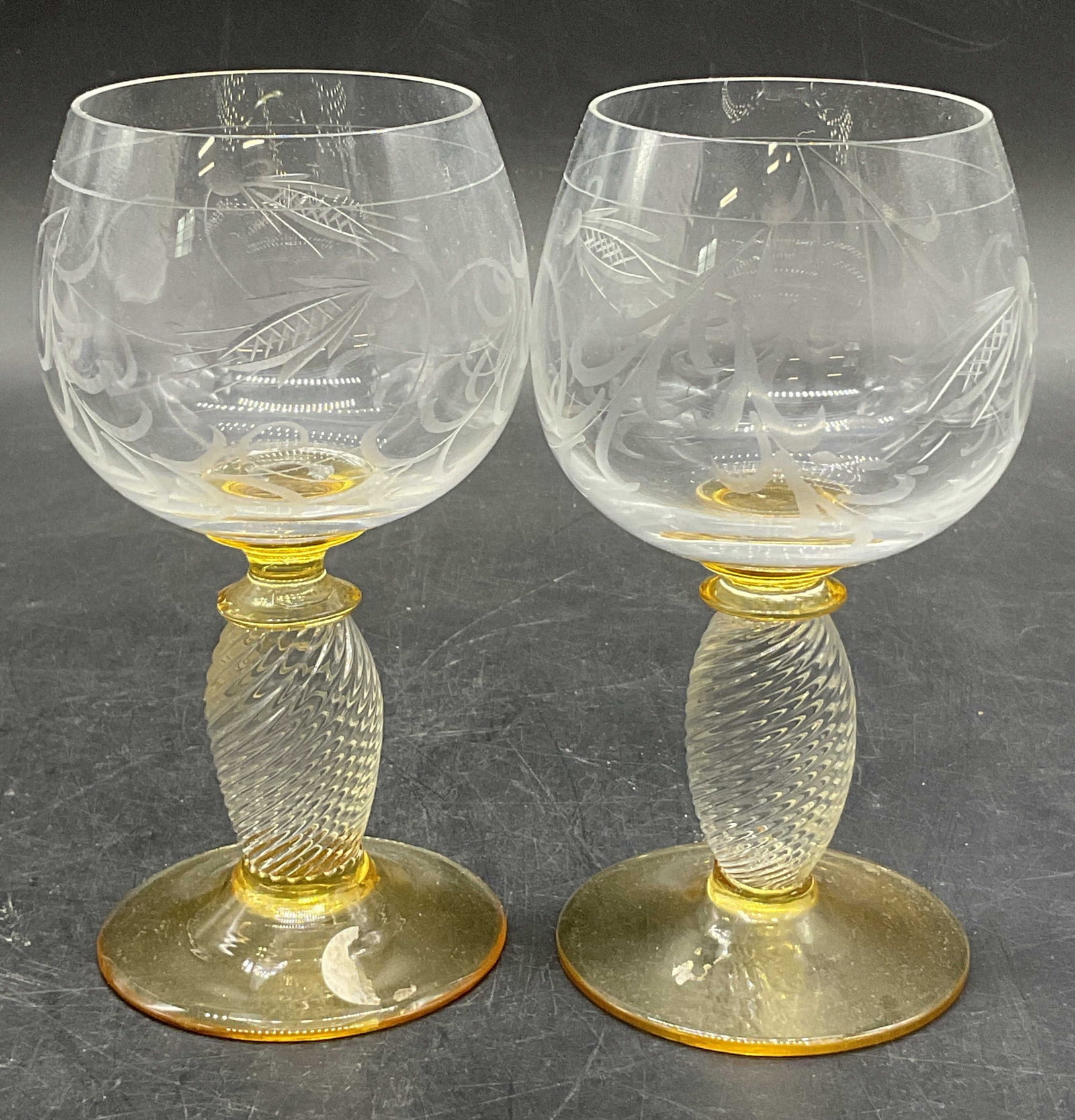 Pair Vintage Blown Etched Crystal Stemware Glasses: Pair Vintage Blown Etched Crystal Stemware Glasses. Foliage motif to the glasses. Amber hued accents to the stem and base. Pontil to the undersides. Measures approx. 5.25H x 2.5W in. Width measured at