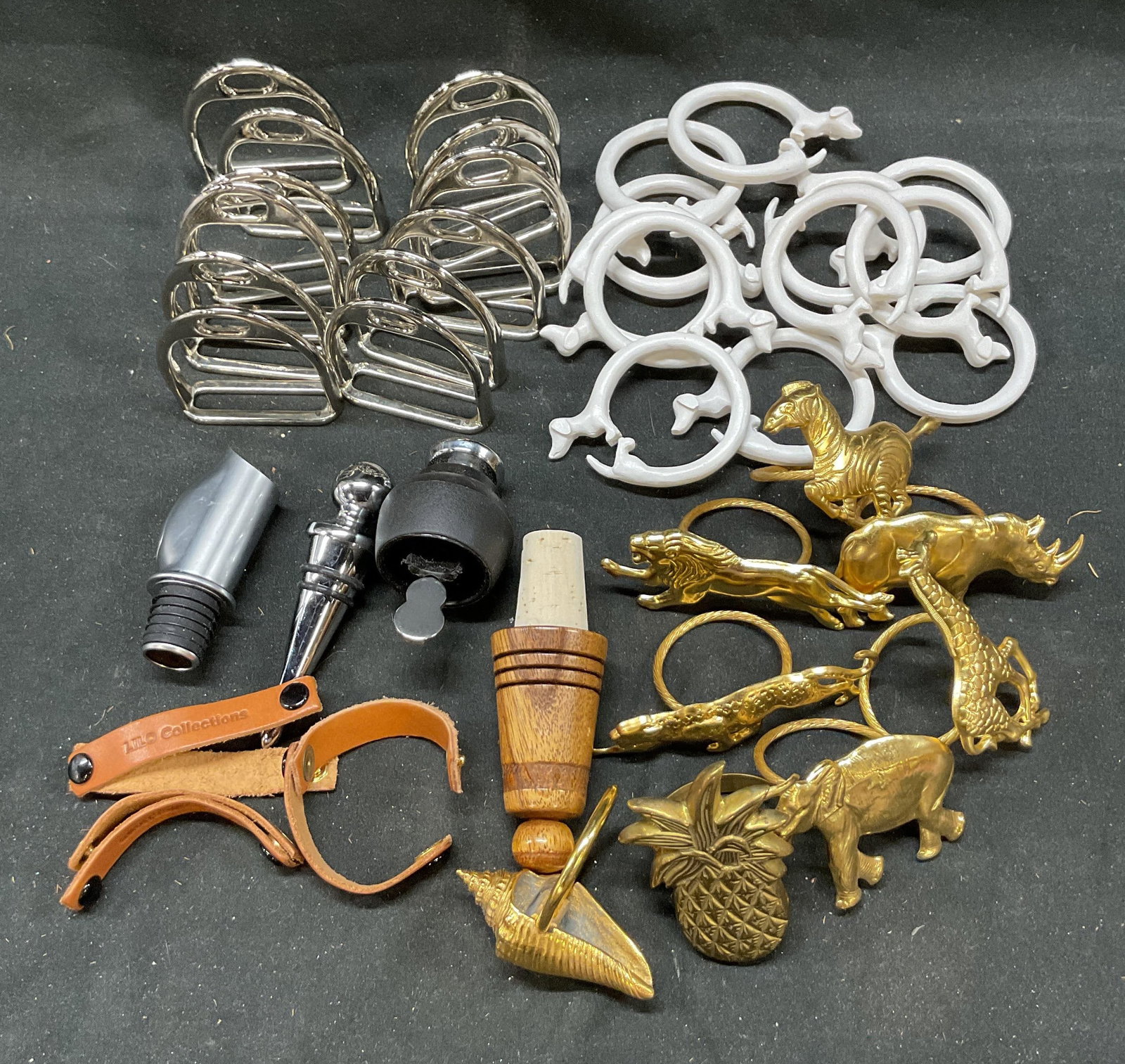 Lot 39 Napkin Rings Stirrups Drawer Pulls Blocker: 12 nickeled brass horse rising stirrup, 12 dachshund round napkin rings, 3 piece wine opening set, 6 gold tone safari animal napkin holder rings, 2 gold tone shell pineapple napkins holders, 3 leather