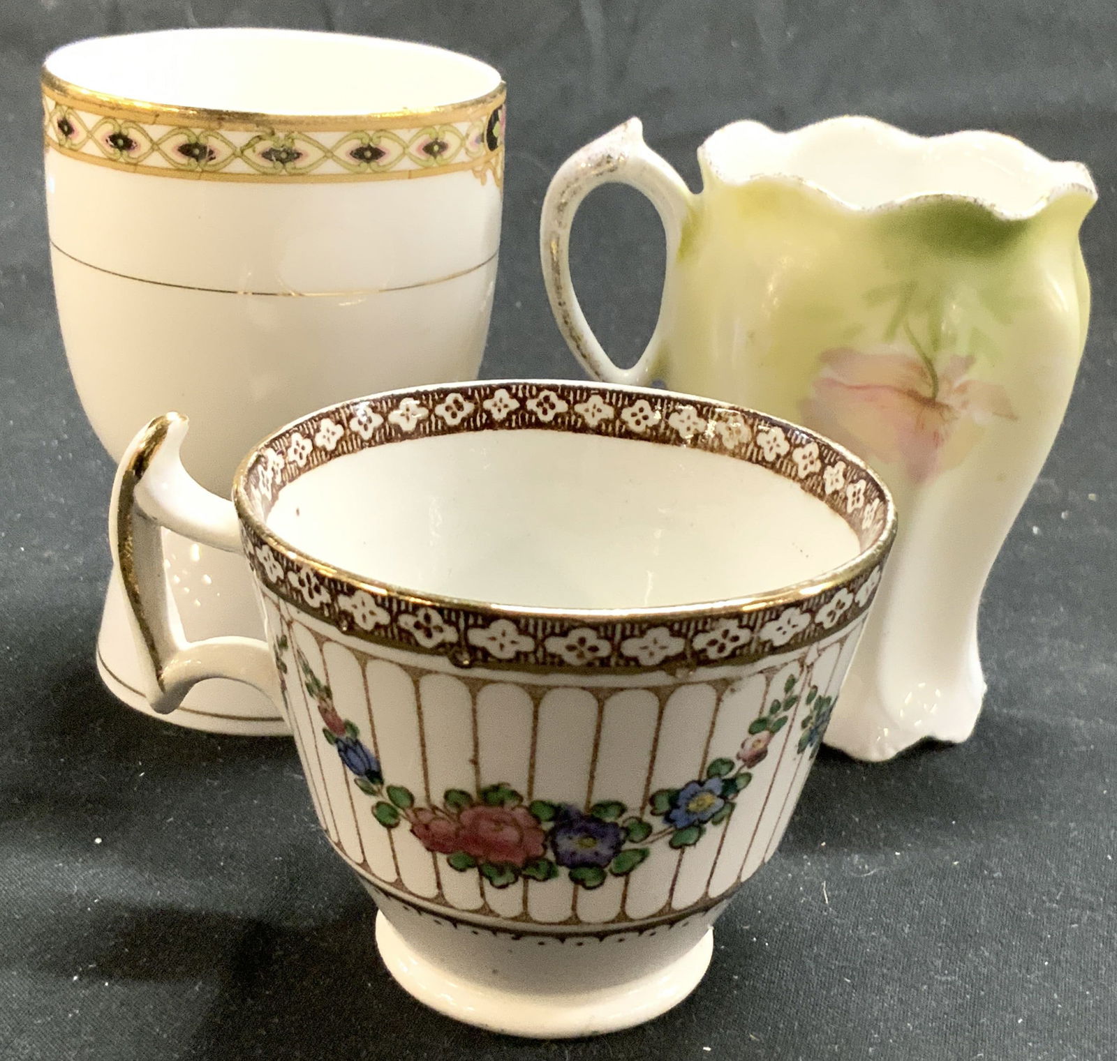 Lot 3 Asst Porc Vessels NIPPON & More: Lot includes 3 porcelain vessels including trademarks such as Noritake Nippon, Booths (England), & RS (Prussia). Lot includes 1 teacup, 1 scalloped teacup and 1 egg coddler. Each piece is vintage. Egg