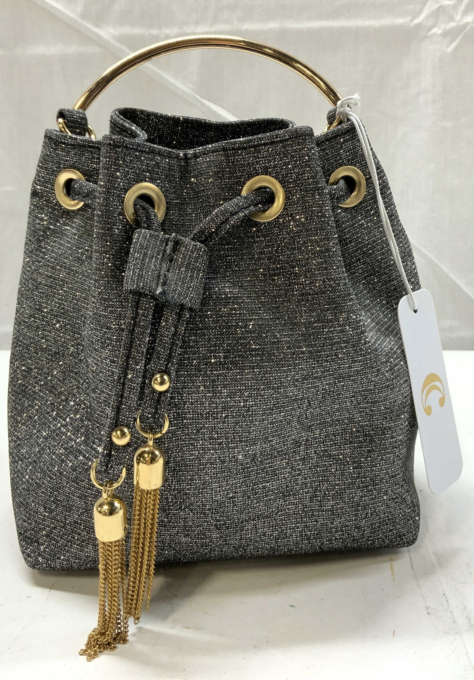 Shimmery Grey Drawstring Bucket Bag NWT: Shimmery Grey Drawstring Bucket Bag NWT Bag featuring a bucket shape with drawstrings. Bag has glitter embellishments. Tags reads distributed by CHARMING CHARLIE, HOUSTON TX. Surface wear consistent t