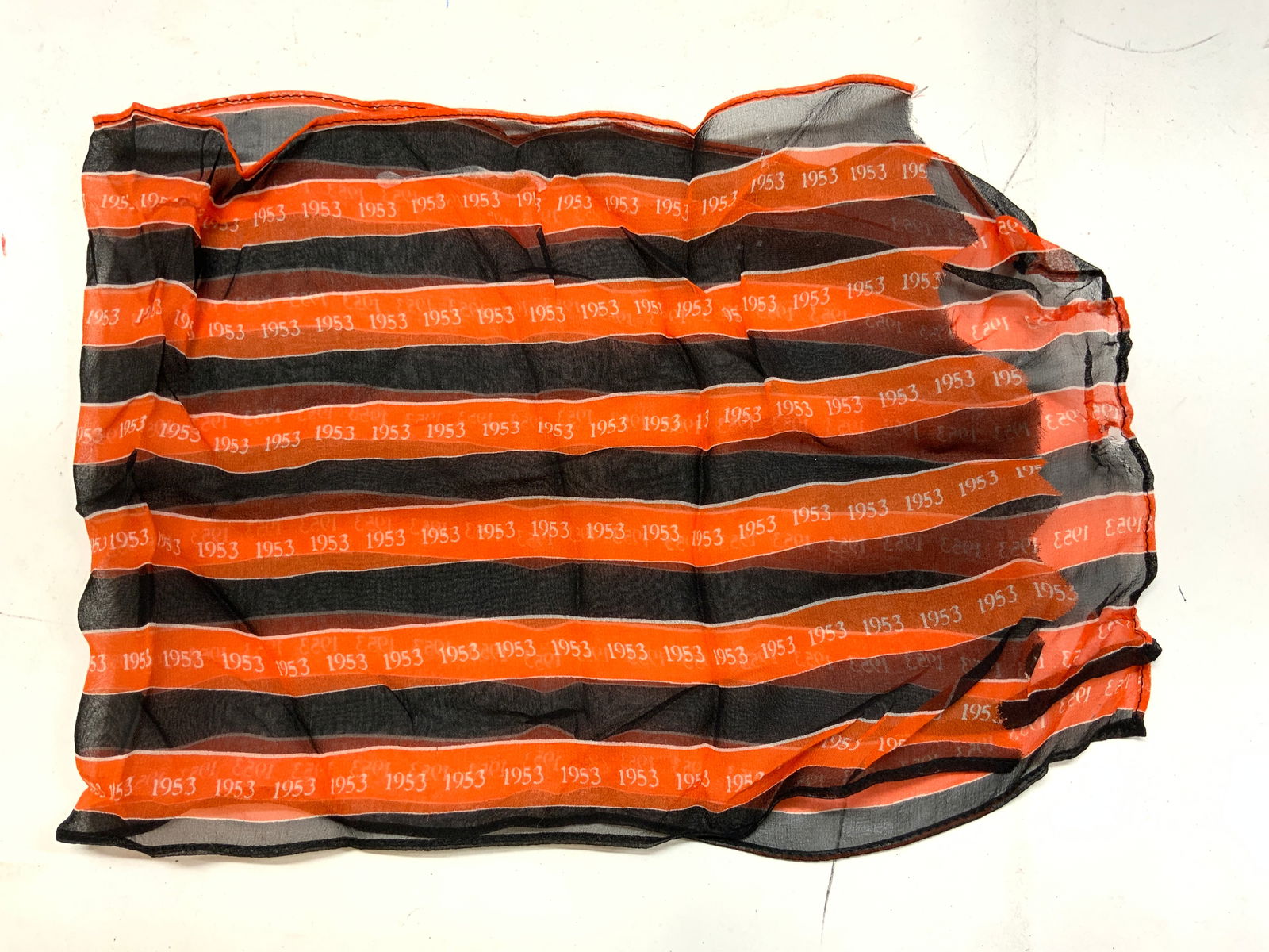 1953 Orange & Black Striped Print Silk Scarf: 1953 Orange & Black Striped Print Silk Scarf Scarf features black & orange vertical stripes. Scarf is adorned with the repeating number 1953 & appears to be silk. Surface wear consistent to age, use &