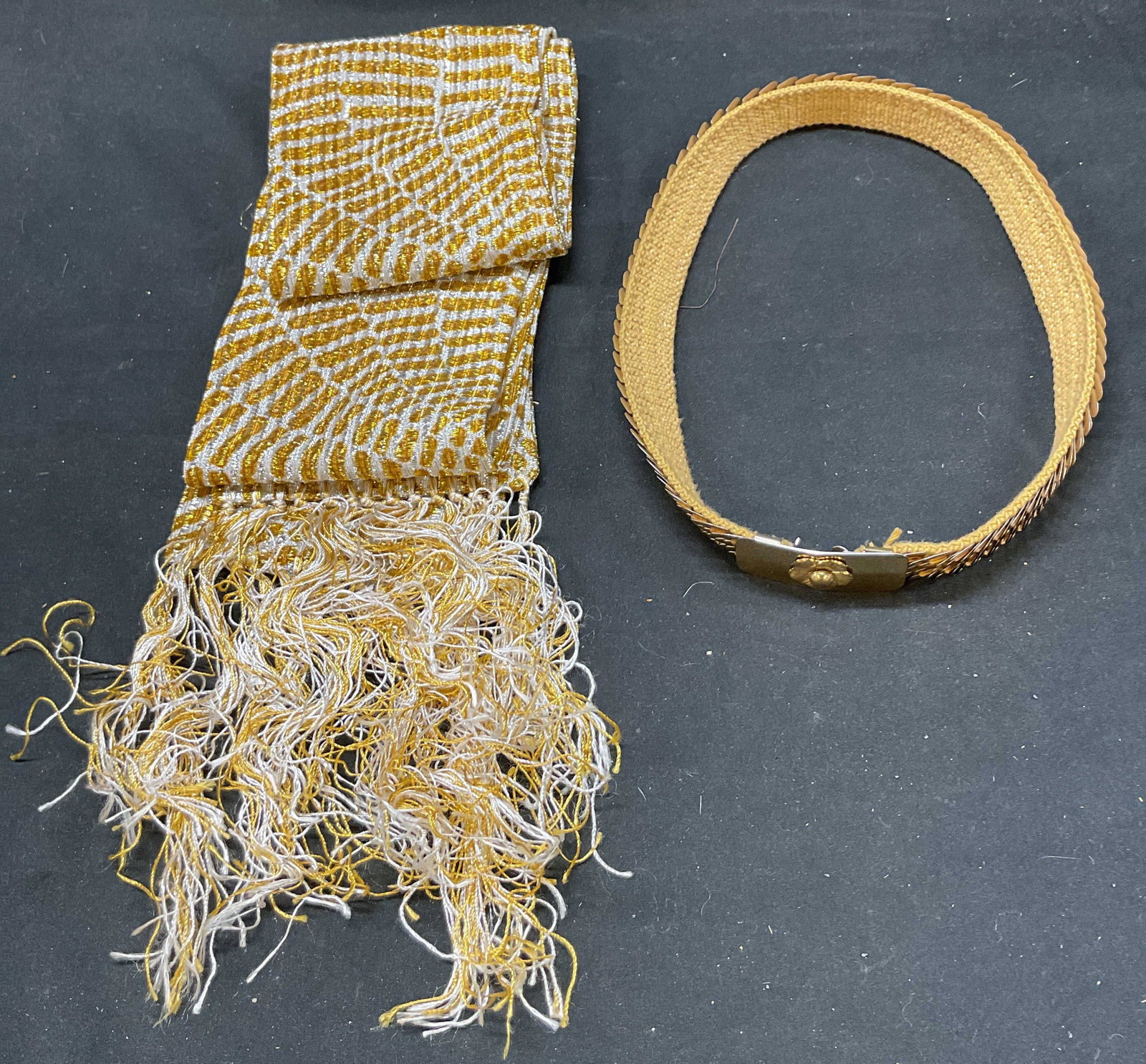 Lot 2 Vtg Gold Tone Metal Belt and Metallic Scarf: Lot 2 Vintage Gold Tone Metal belt metallic scarf. Belt length approx. 25 inches. Hook closure. Tan material appears to be wool or wool style woven material. Metallic gold and white scarf with fringes