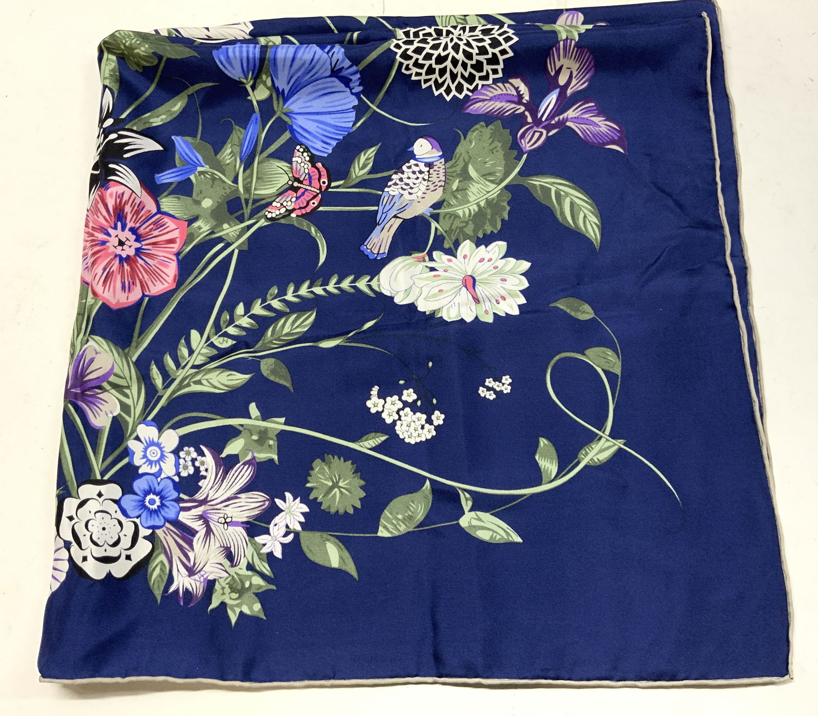Dark Blue Botanical Bloom Print Silk Scarf: Dark Blue Botanical Bloom Print Silk Scarf Scarf featuring a floral pattern print on a dark blue background. Pattern consists of colorful flowers & leafs. Surface wear consistent to age, use & exposur