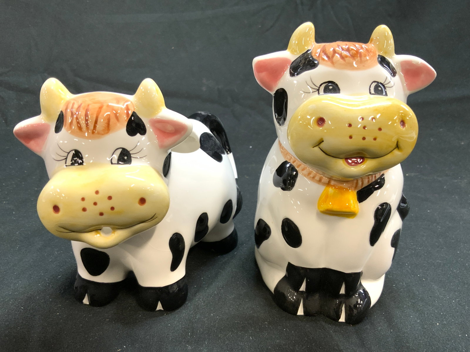 HOUSTON HARVEST Porc Cow Creamer & Sugar: Undersides are marked HOUSTON HARVEST. Lot includes 1 Creamer, & 1 sugar dish. Each are porcelain and are in the form of cows. Sugar dish includes lid & measures approximately 5.5 inches tall 3 inches