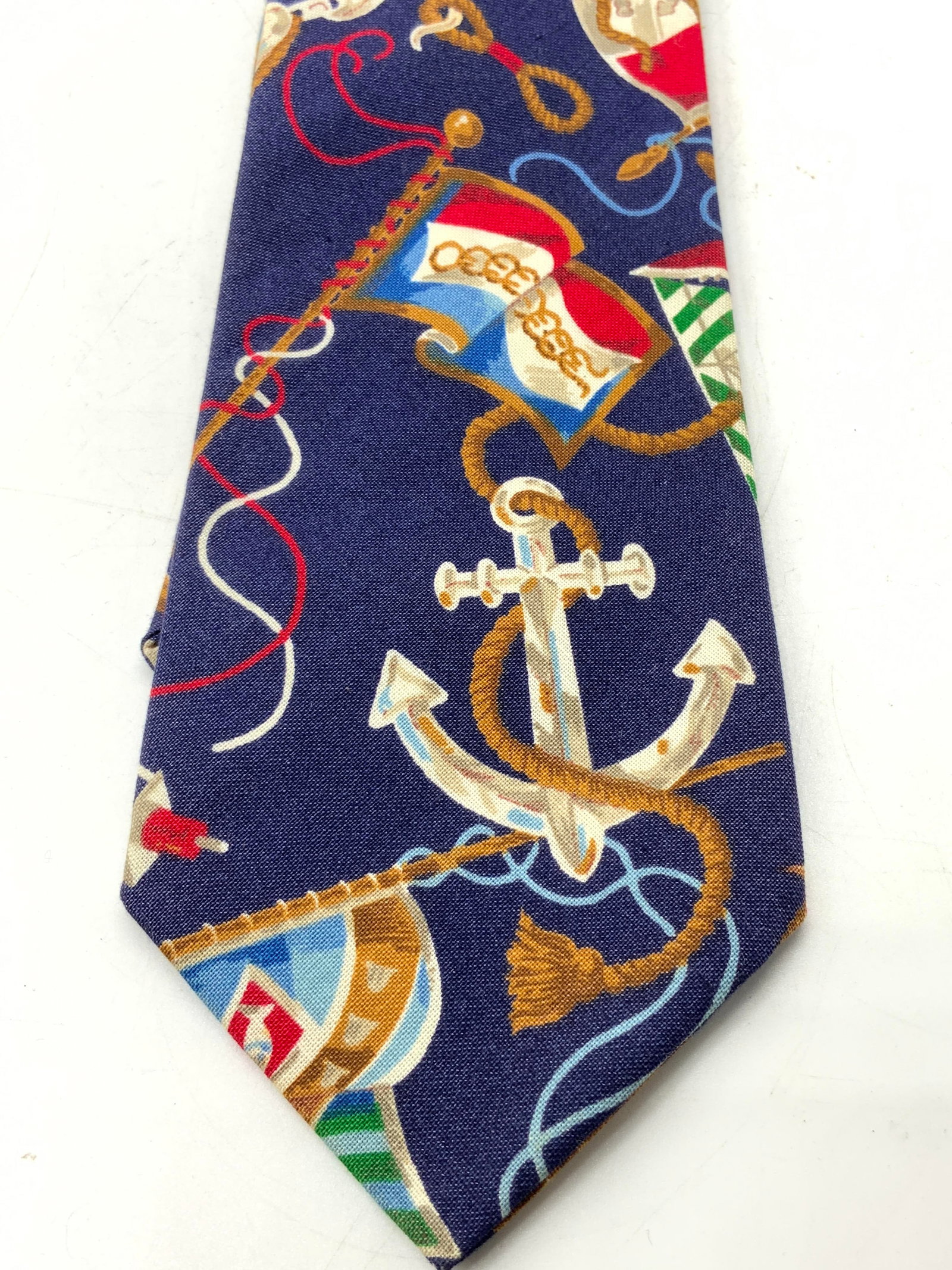 San-Ria Nautical Theme Tie NEWPORT, RHODE ISLAND: San-Ria Nautical Theme Tie NEWPORT, RHODE ISLAND Navy mens tie featuring a nautical theme with anchors & maritime symbols. Signed & marked. Reads San-Ria. Newport, Rhode Island. Surface wear consisten
