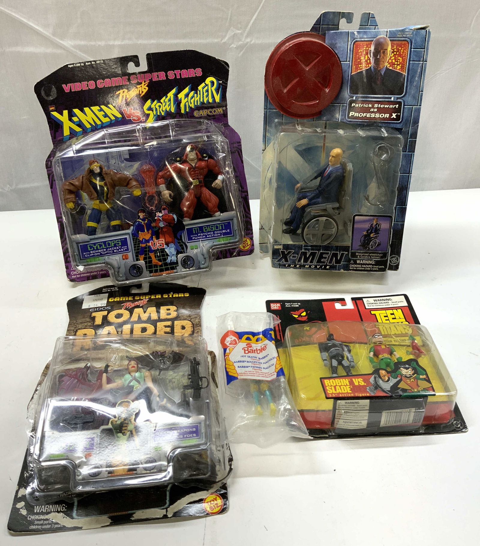 Lot 5+ Vntg Assorted Action Figures NIP MARVEL+: Lot 5+ Vntg Assorted Action Figures NIP MARVEL+ Lot includes MATTEL Barbie figure, 2004 Teen Titans action figures, 1997 Tomb Raider figure, 1997 X-Men vs Street Fighter action figures & 2000 MARVEL X