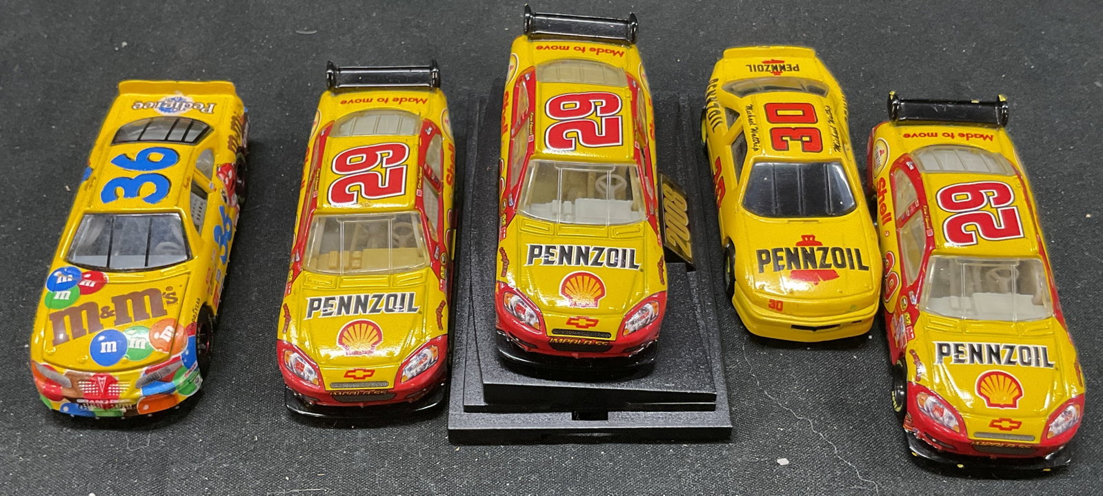 Lot 4 Vtg 1990-2010s Collectible NASCAR Toy Cars: Lot 4 vintage 1990-2010s collectibles yellow toy race cars. NASCAR Model car Collectibles. Featuring multiple sponsors. Marked on underside. M and Ms, Pennzoil. Metal and composite materials. Surface 