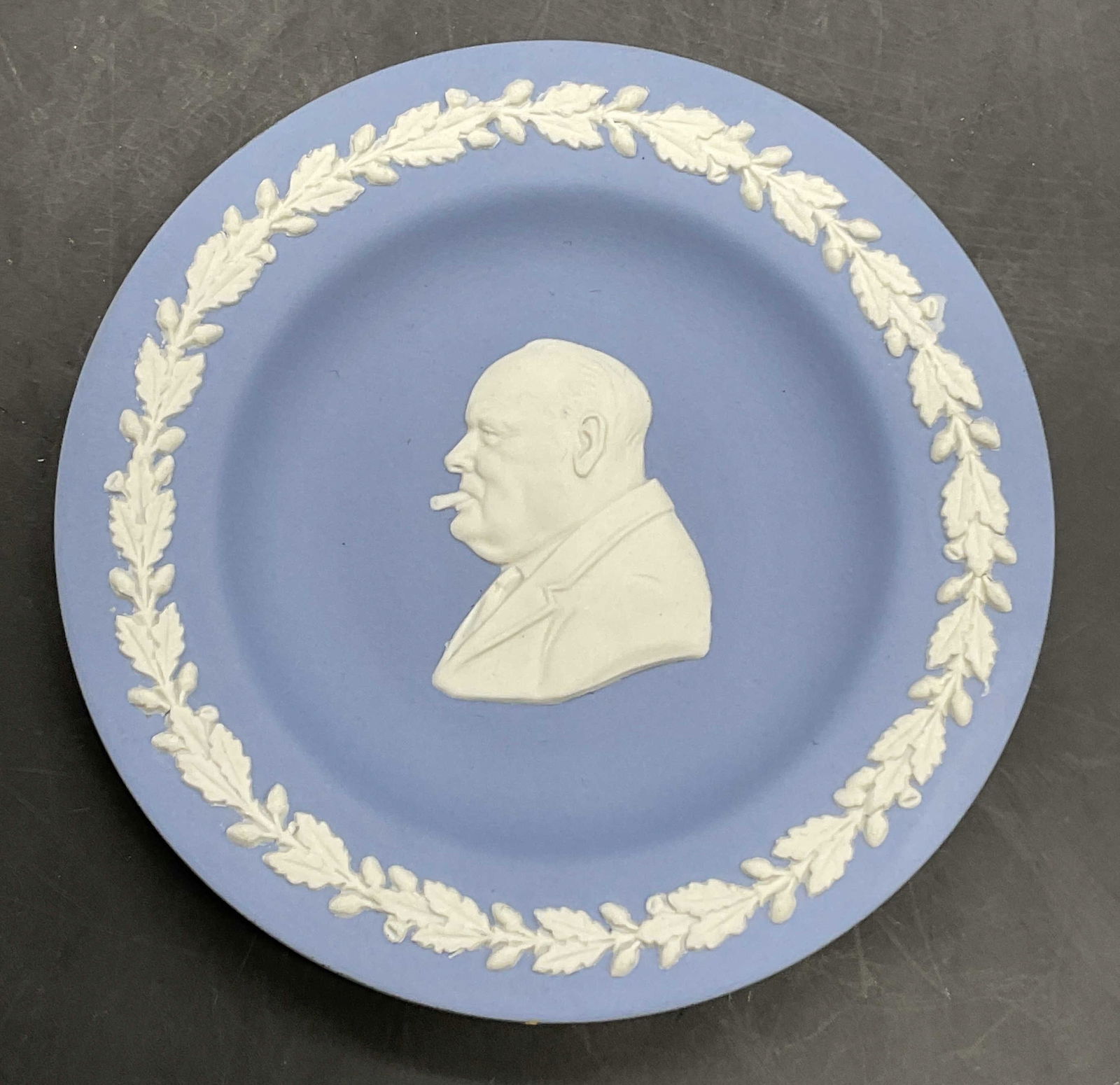 WEDGWOOD ENGLAND Blue Jasperware Trinket Dish: WEDGWOOD ENGLAND Blue Jasperware Trinket Dish. Central motif depicts Winston Churchill. Underside signed WEDGWOOD, Made in England. Measures approx. 4.5L x 4.5W in. Residue, discoloration, and surface