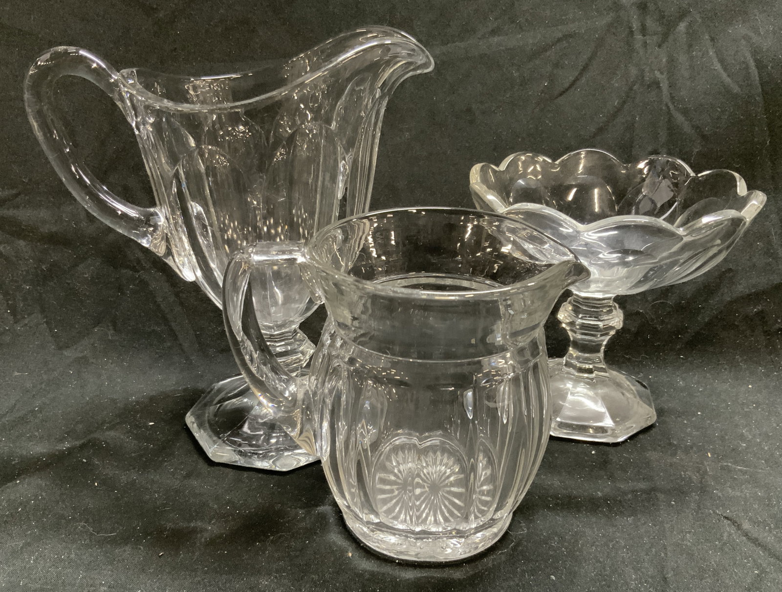 Lot 3 Assorted Art Glass Vessels Heisey & More: 2 marked with H hallmark in triangle, appear to be Heisey. Lot includes 1 pedestaled pitcher, 1 pedestaled candy dish & 1 scalloped pitcher. Each pedestaled dish has octagonal form bases. Candy has ro