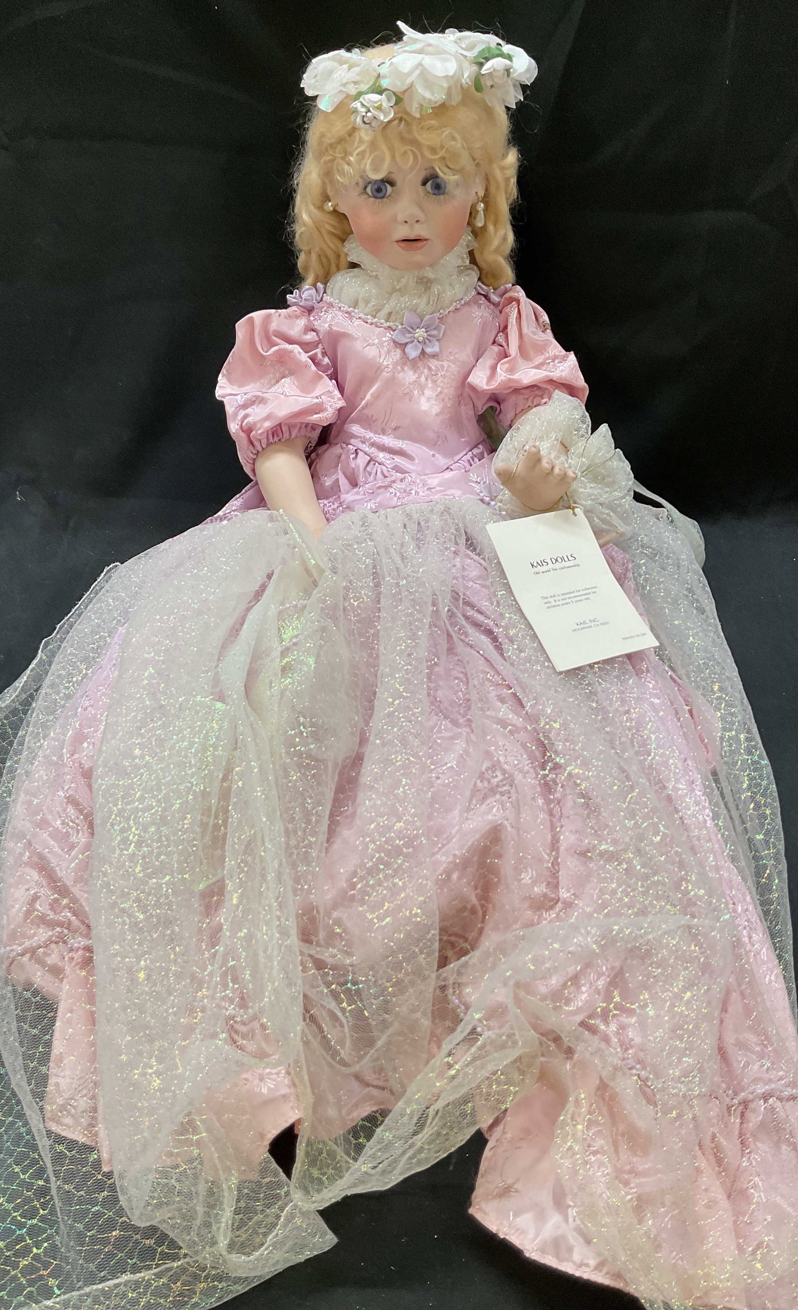 Vtg Kais Collectors Porcelain Doll USA: Vintage Kais collectors porcelain doll. Made in USA. Old World Fine Craftsmanship. Blonde girl doll with flower headband and floral pink ball gown. Puffed sleeved design. Separate cape included. All t