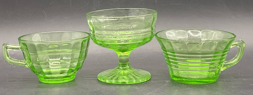 Lot 3 Vintage Uranium Glass Cups, Teacups +: Three Vintage Uranium Glass Cups. Two teacups and one stemmed glass. Pieces glow under blacklight. Tallest measures approx. 3.25H x 3.5W in. Surface wear consistent with age, use, and exposure. Some c