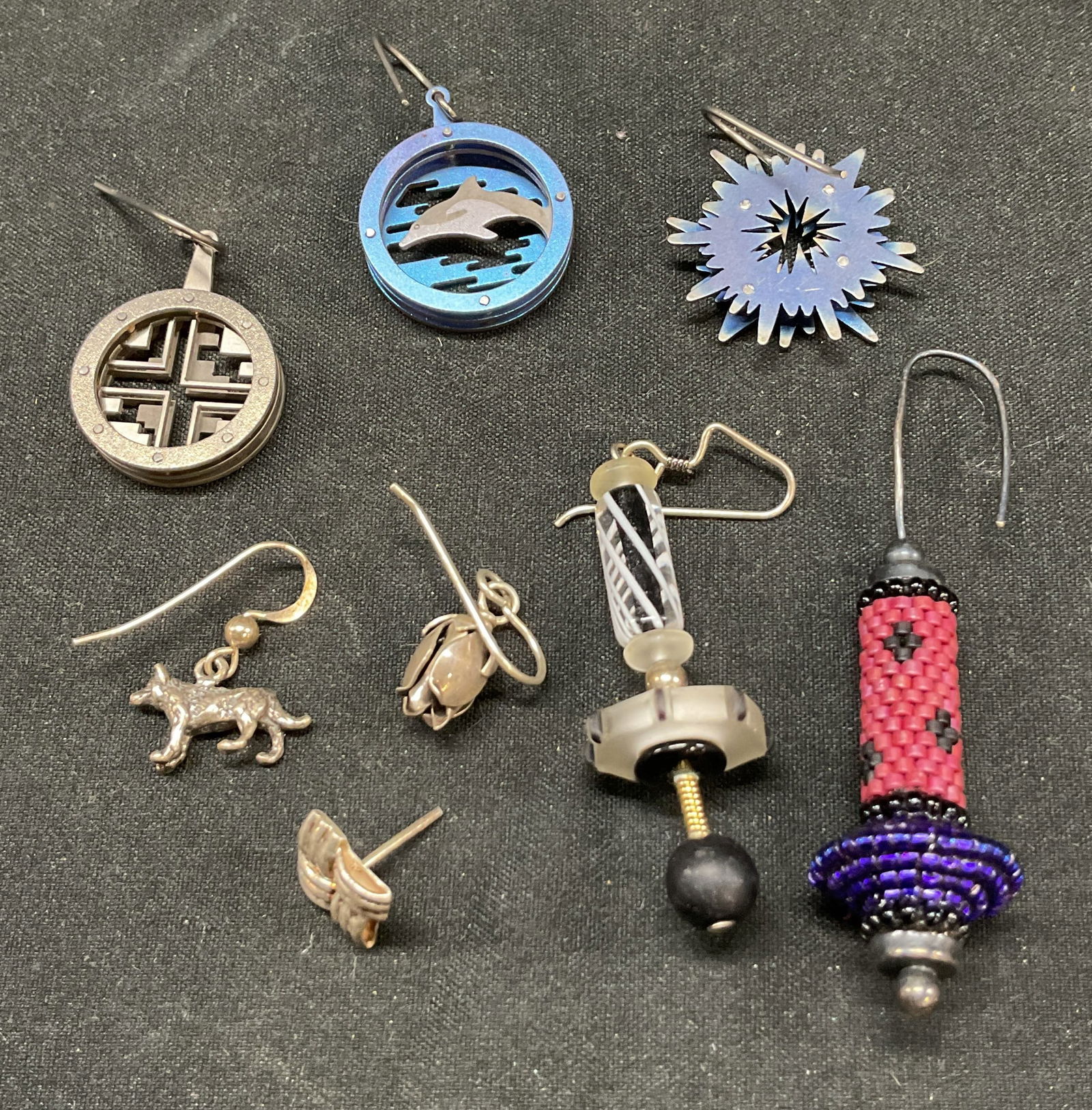 Lot 8 Assorted Beaded Silver Plated Earrings: Lot 8 assorted beaded silver plated earrings. Lot includes geometric, dolphin, star, floral, beaded pattern designs. Various colors. Crafted from metal, beads, and composite materials. Fishhook backin