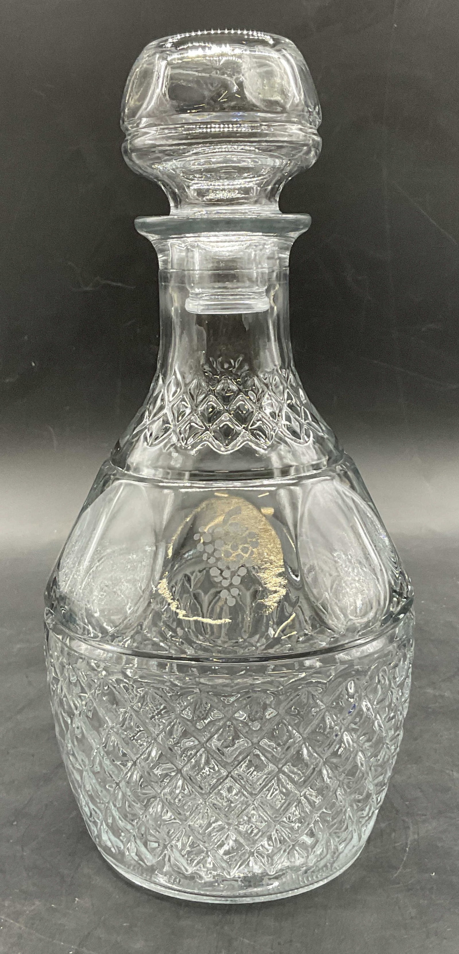 Vintage Cut Glass Grape & Crown Motif Decanter: Vintage Cut Glass Grape & Crown Motif Decanter With Stopper. Thick walled and weighty. Glass seam present. Measures approx. 10H x 4W in. Surface wear consistent with age, use, and exposure. home decor