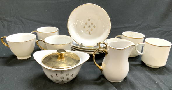 13 Fleur De Lis Partial Porcelain Tea Set: Lot includes 5 saucers, 3 teacups, 3 coffee cups, 1 creamer dish, and 1 sugar dish. Each piece is white with gilt detail. Underside of saucers reads Fleur Lis. Tea set is vintage. Saucer measures appr