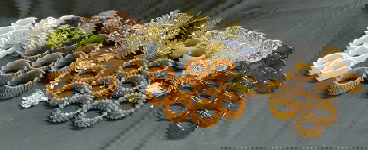Lot 20+ Assorted Napkin Rings: Multiple napkin ring sets. Lot includes crystal napkin rings, gilt metal, beaded, woven wicker, porcelain, woven leatherette, amber glass, pewter, and polka dotted napkin rings. Leaf form gilt metal n