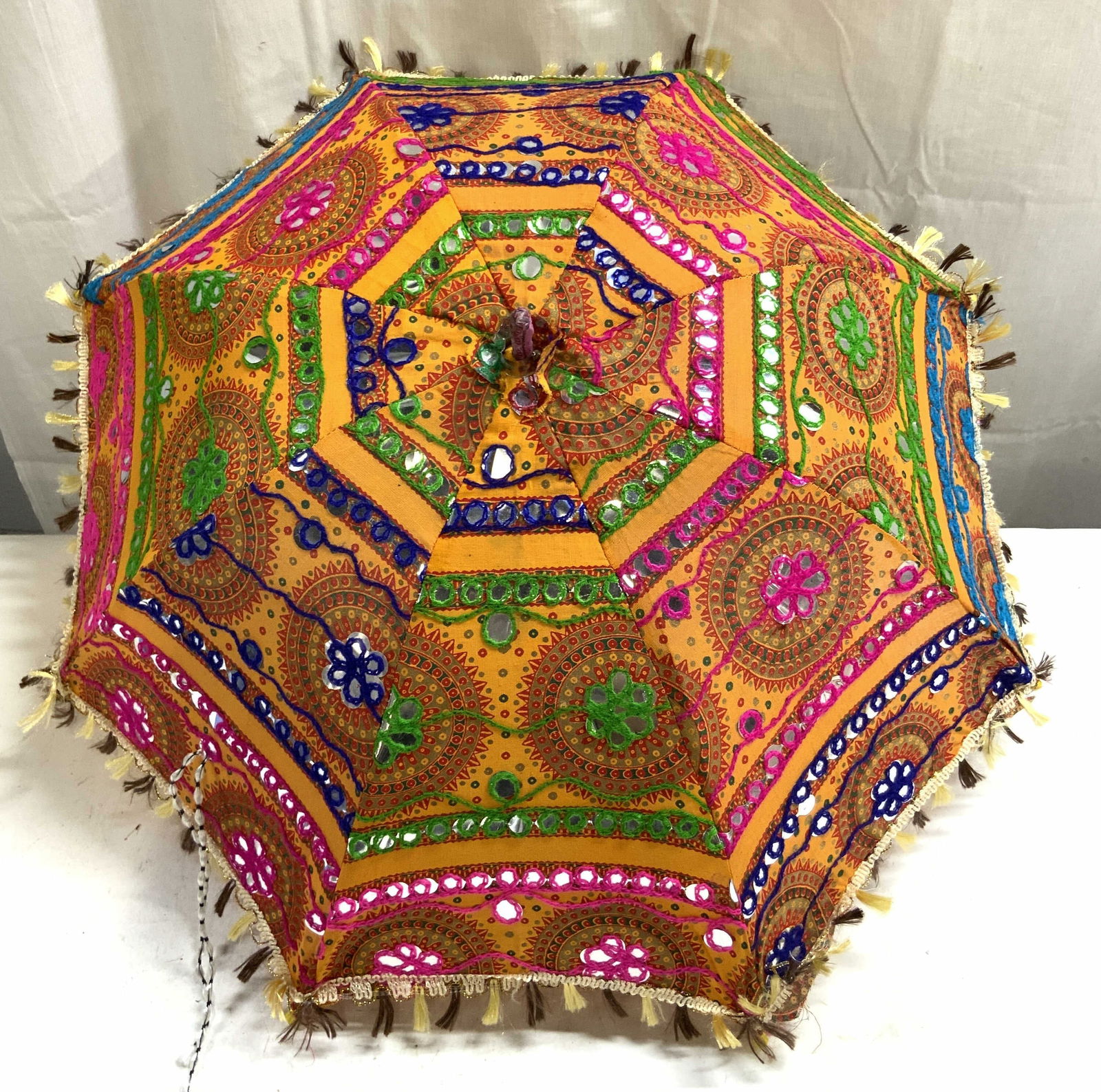 Rajasthani Cotton Fabric Handmade Umbrella: Umbrella is vintage. Piece is crafted from cotton& other fabrics. Appears to be hand made. Intricate floral, & geometric patterned detail. Rajasthani umbrella. Piece measures approximately 23 inches t