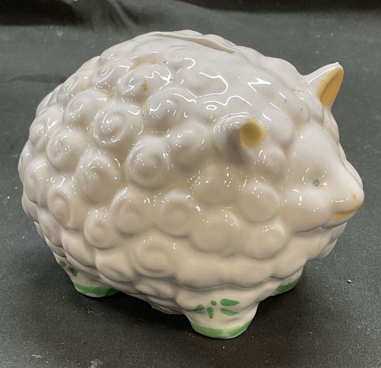 Vintage Hand Painted Ceramic Sheep Coin Bank: Vintage ceramic sheep motif coin bank, hand painted white and green. Measures approx 4.5 x 3.5 x 3.5 inches. Some scratching observed. Coin bank, sheep bank, ceramic bank, vintage coin bank, piggy ban