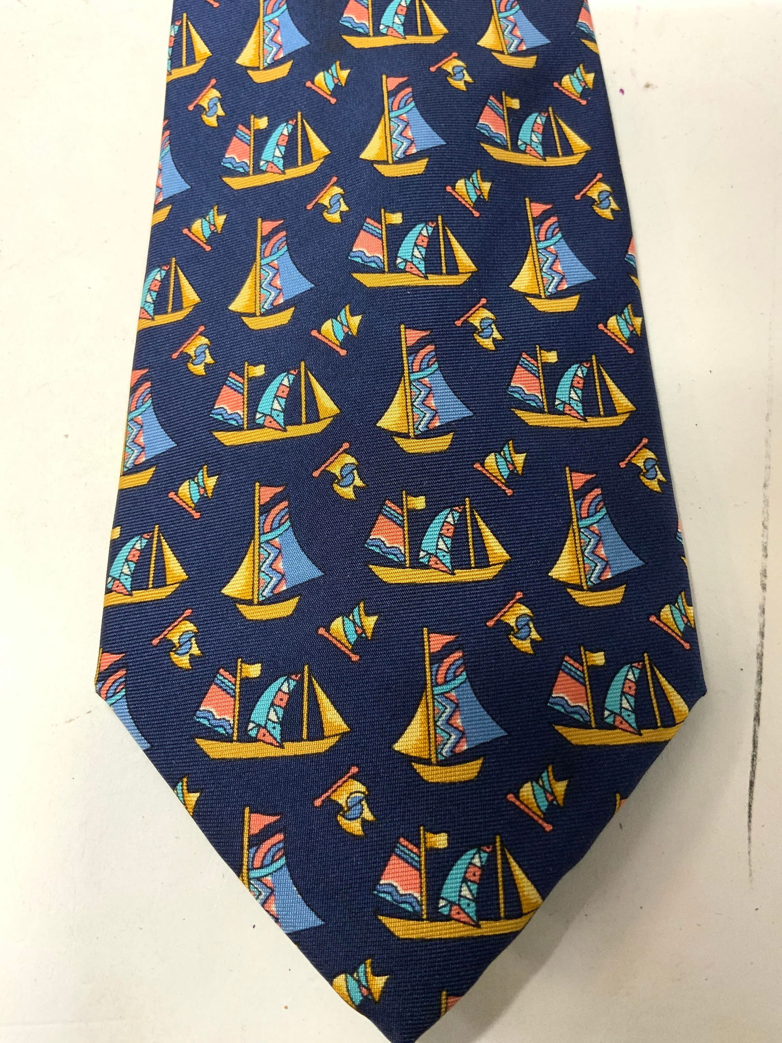 SMITHS BERMUDA Sailing Boat Silk Tie ITALY: SMITHS BERMUDA Sailing Boat Silk Tie ITALY Silk tie features colorful sailboats on a dark blue background. Signed & marked. Reads SMITHS BERMUDA ITALY. Surface wear consistent to age, use & exposure.