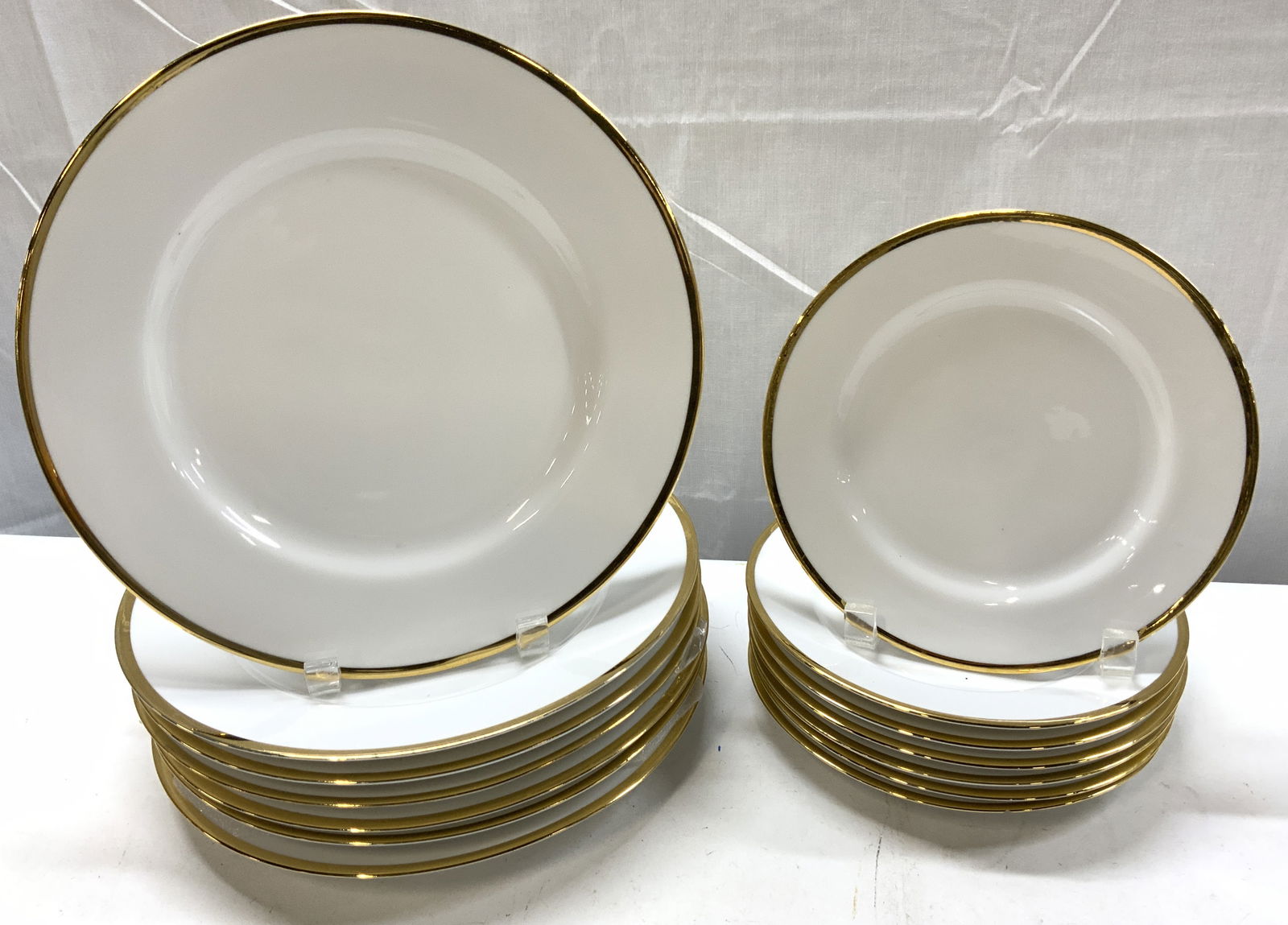 Lot 14+1995 THE CELLAR Monno Plates BANGLADESH: Lot 14+1995 THE CELLAR Monno Plates BANGLADESH 7 salad plates & 7 dinner plates. Plates are white & feature a gold rim. Signed & marked on underside. Reads THE CELLAR, MONNO BANGLADESH 1995. Surface w