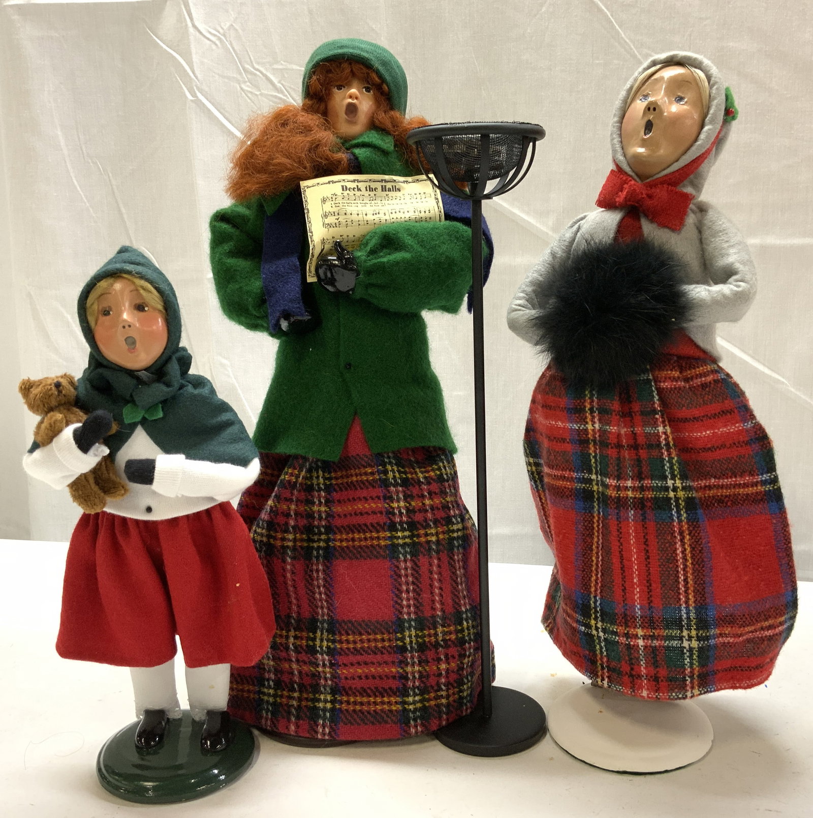 Lot 3+ 1980-2010s Byers Choice&Sabatte Figurines: Lot 3+ 1980-2010s Byers Choice&Sabatte Figurines Figurines have hand-painted faces & are wearing plaid skirts & appear to be singing. Figurines are standing on a green base. Underside is signed & mark