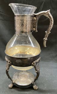 1940s F.B. Rogers Silver Plated Footed Carafe: 1949s F.B. Rogers silver plated footed carafe. 2 piece Silver plated glass footed tea coffee carafe with warming stand. Antique carafe. Art nouveau style design. 13 x 5 inches put together. Some surfa